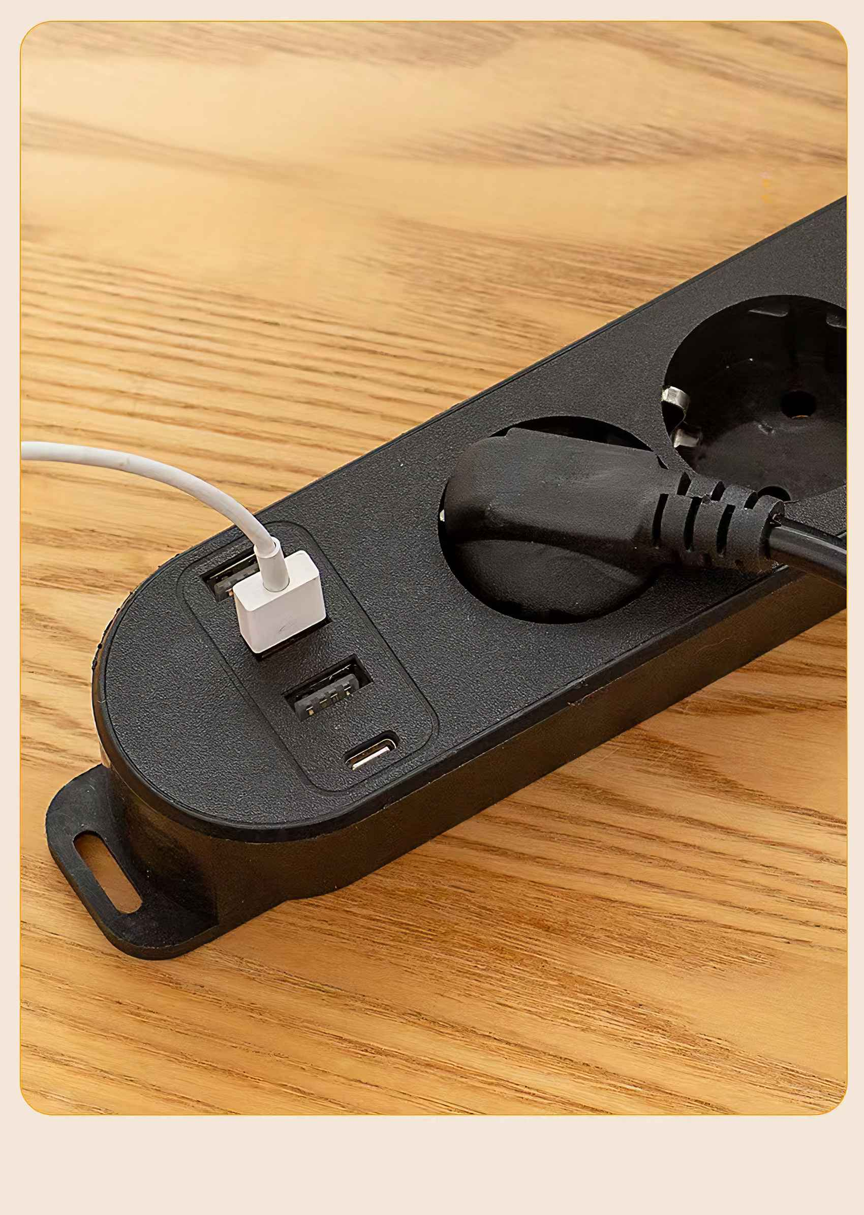 Schwarze Steckdosenleiste mit eingesteckten Kabeln auf Holzoberfläche. Weißes USB-Ladegerät ist angeschlossen.