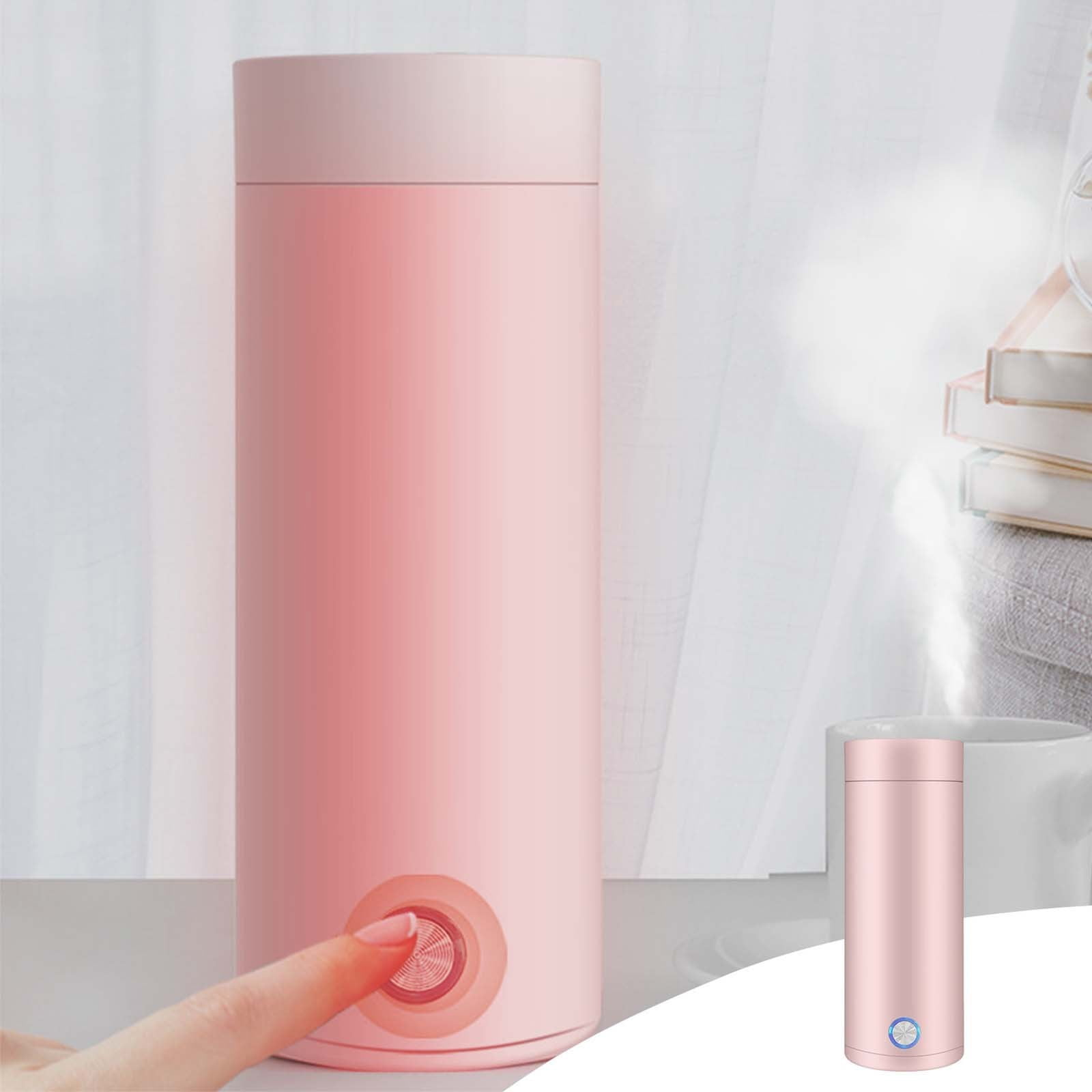 Ein rosa Reisekessel wird gezeigt, ein Finger drückt die Ein-Aus-Taste. Daneben steht ein kleinerer Wasserkocher. Im Hintergrund eine Tasse und Bücher.