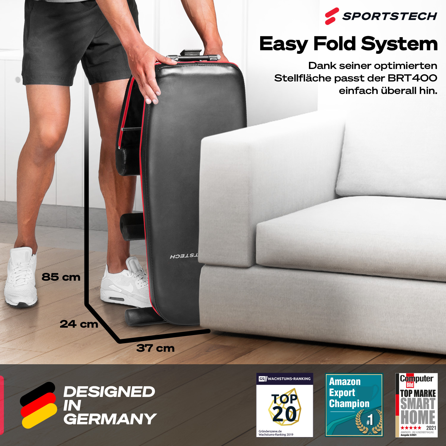 Ein Mann hält eine schwarz-rote, zusammenklappbare Trainingsbank neben einem weißen Sofa. Text auf der Bank lautet SPORTSTECH Easy Fold System.