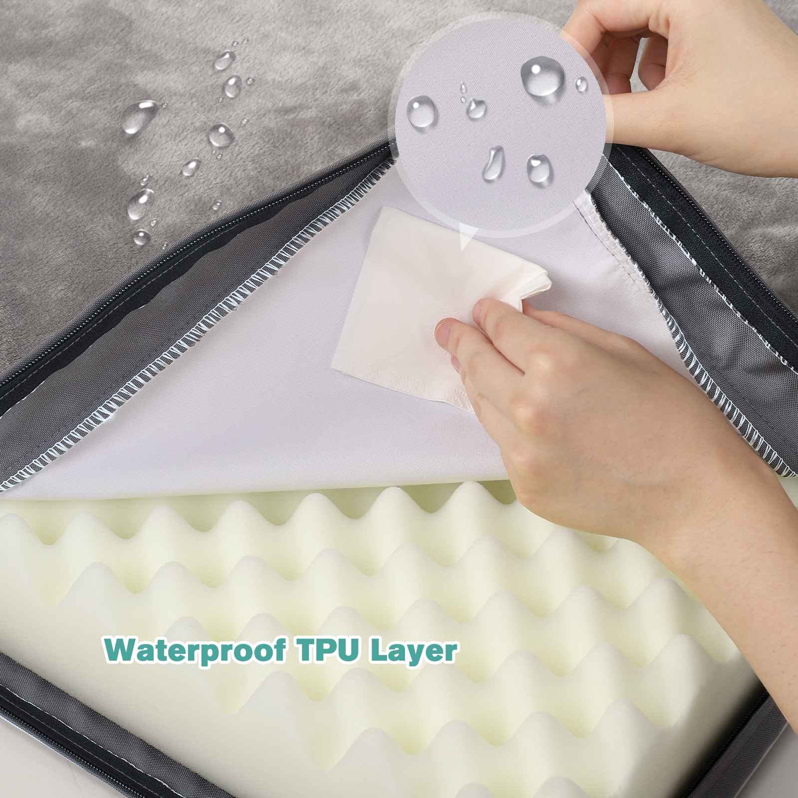 Eine Hand hält einen weißen Wischer über einer Schaumstoffschicht. Wassertropfen sind auf grauem Stoff.
