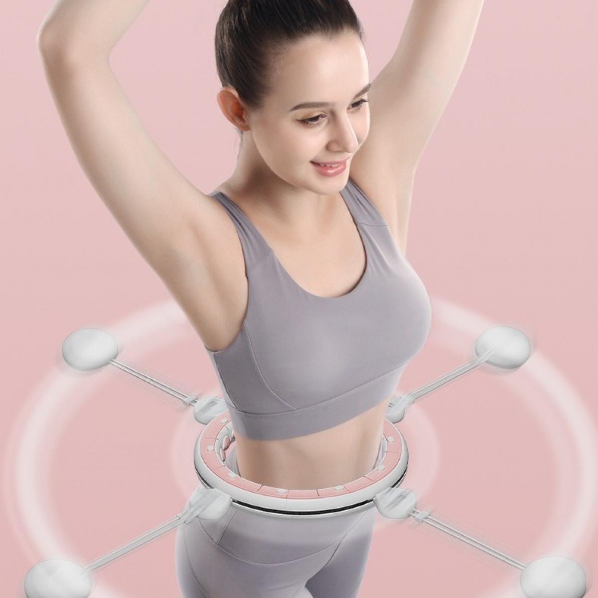 Frau trainiert mit einem gewichteten Hula-Hoop-Reifen. Sie trägt einen grauen Sport-BH und Leggings. Der Hintergrund ist rosa mit konzentrischen Kreisen.
