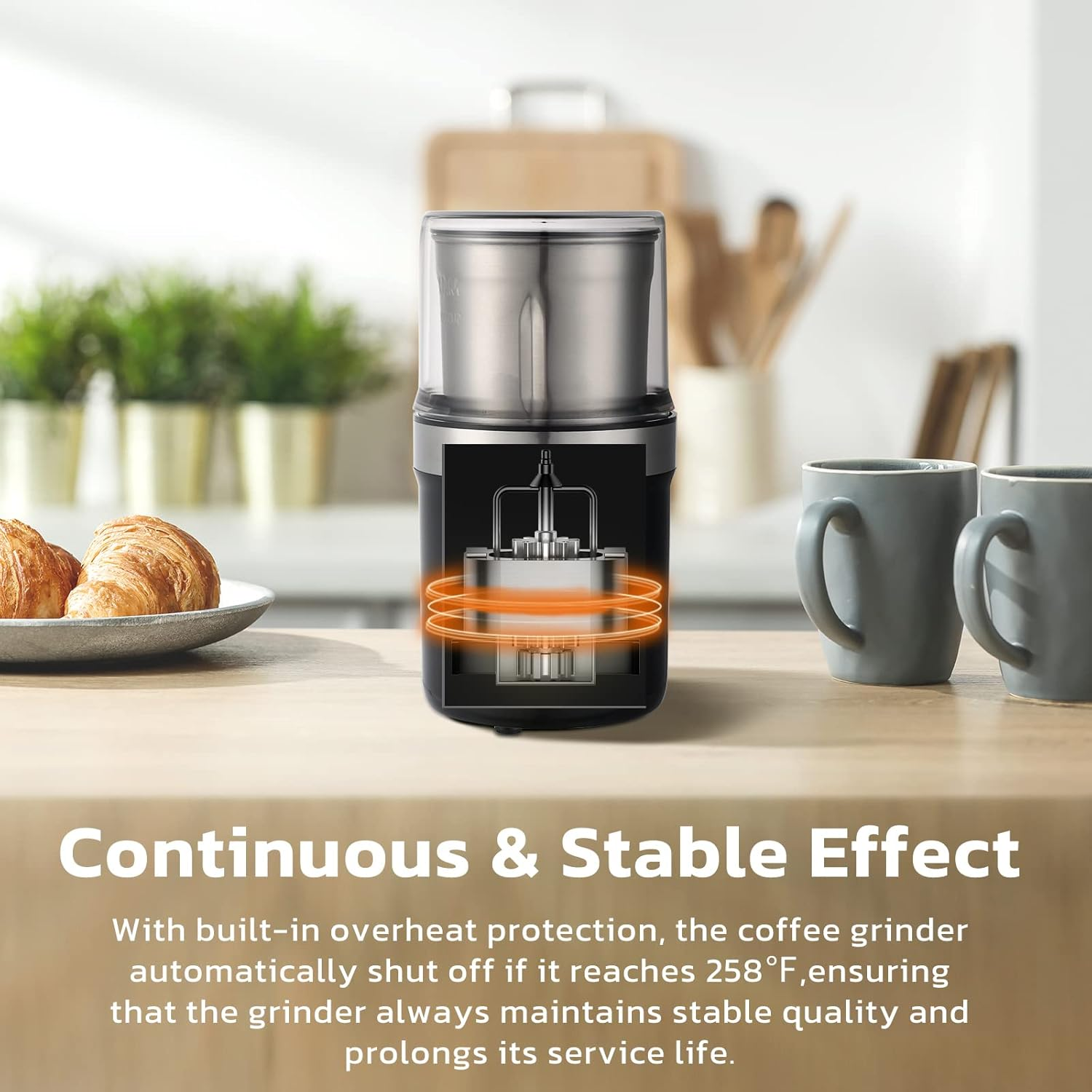 Eine schwarz-silberne Kaffeemühle auf einem Holztisch. Zwei Croissants, zwei graue Tassen und Text über die Eigenschaften.