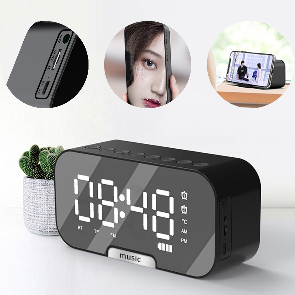 Schwarze Digitaluhr mit Spiegelfinish. Telefon mit Frauenporträt und eines mit Video in der Nähe. Eine kleine Pflanze links.