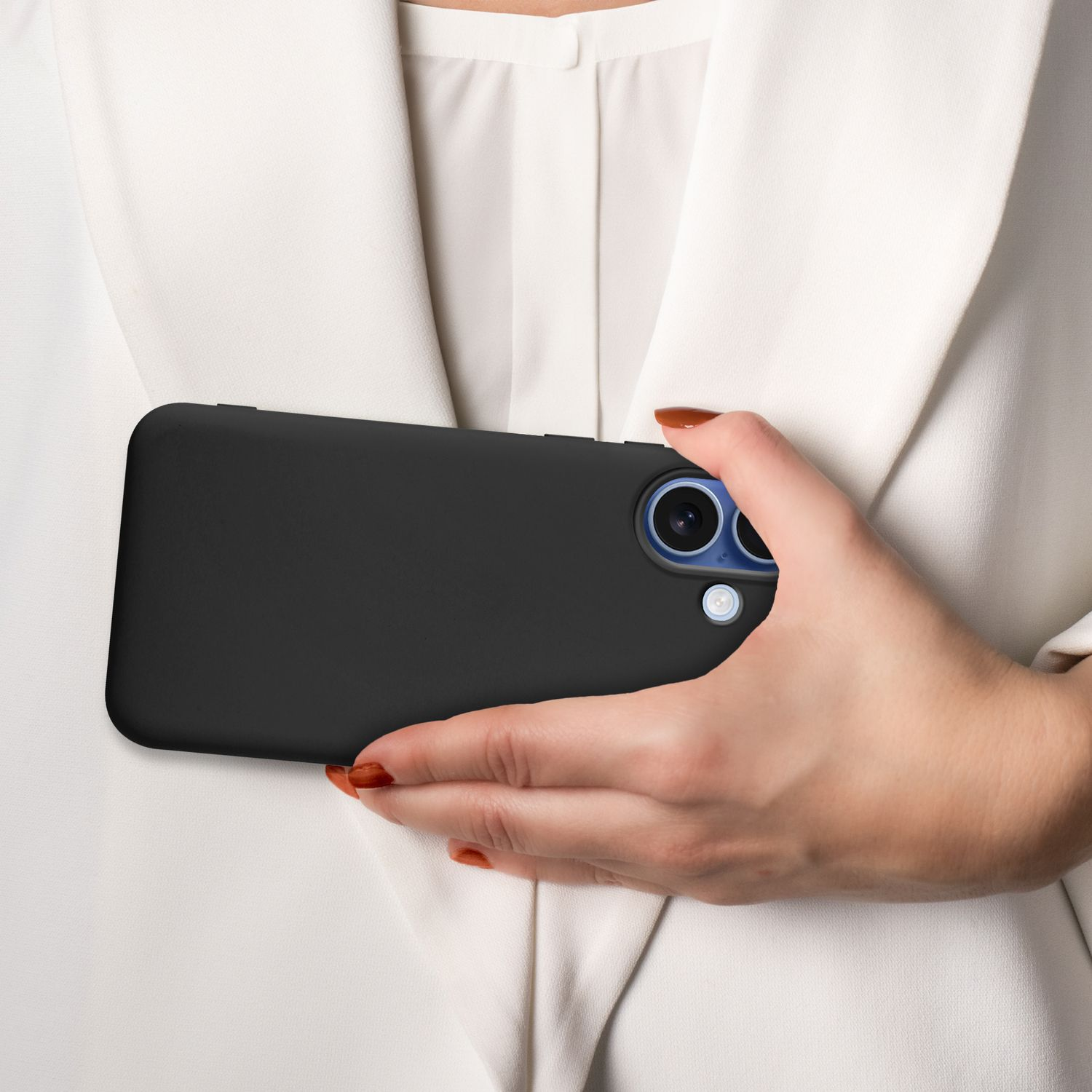 Eine Frau hält ein schwarzes Telefon. Das Telefon hat blaue Kameralinsen. Sie trägt eine weiße Bluse. Der Hintergrund ist verschwommen.