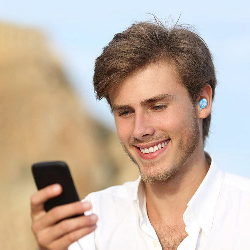 Ein lächelnder Mann mit Ohrhörern hält ein Telefon. Er trägt ein weißes Hemd, hat braune Haare und einen Bart. Blauer Himmel im Hintergrund.