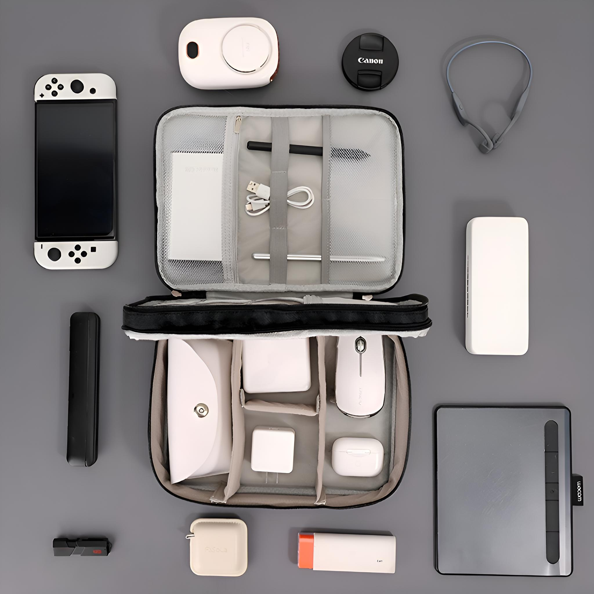 Anordnung von technischen Geräten, darunter ein Switch, eine Maus, Kopfhörer, ein Tablet und Zubehör auf grauem Untergrund.