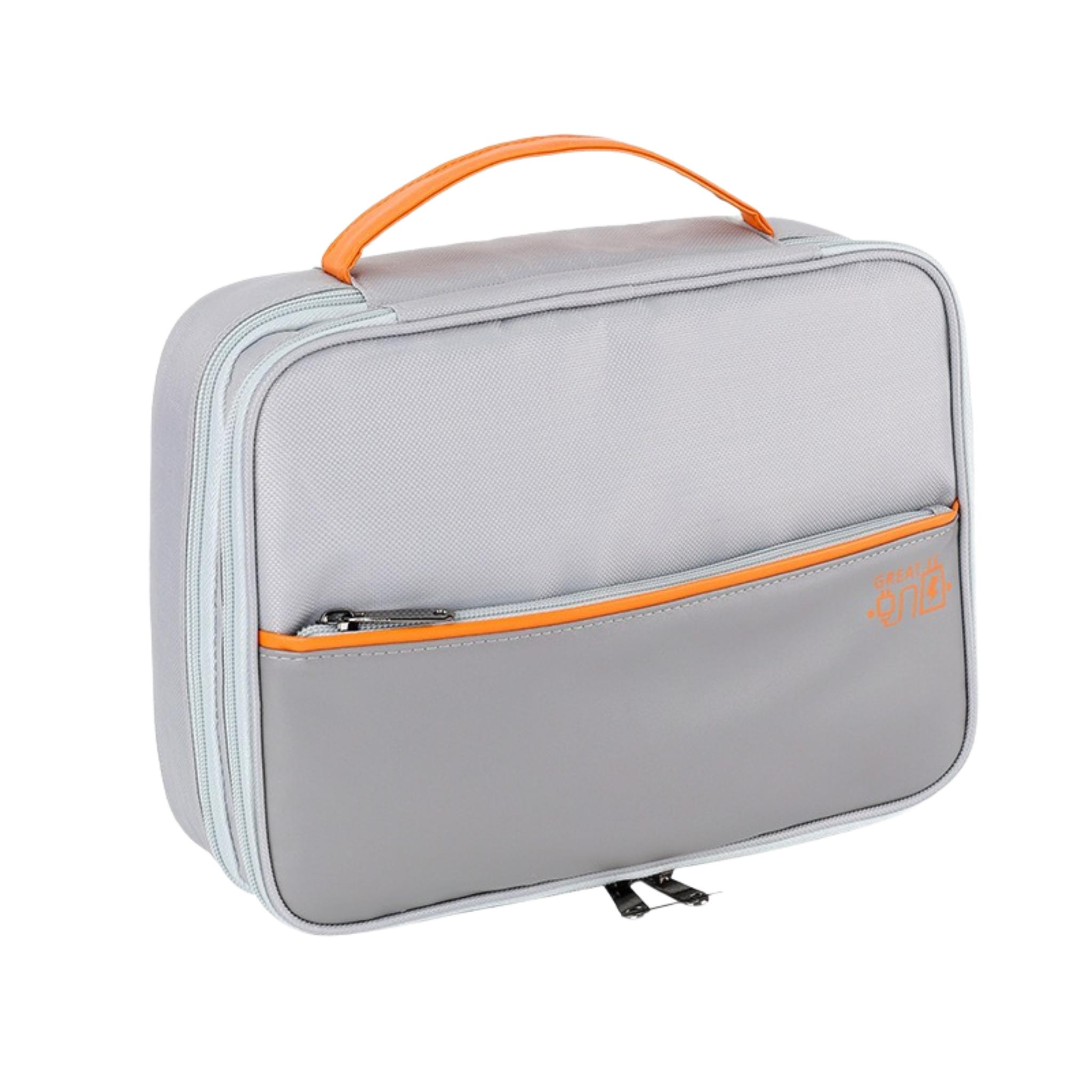 Eine graue rechteckige Lunchtasche mit orangefarbenem Griff und Reißverschluss. Hat eine Seitentasche und einen schwarzen Reißverschluss.