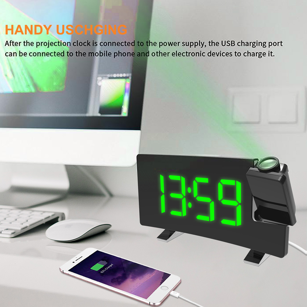 Schwarze Digitaluhr zeigt 13:59. Ein Telefon lädt. Grüner Laser projiziert von der Uhr. Computer und Tastatur im Hintergrund.
