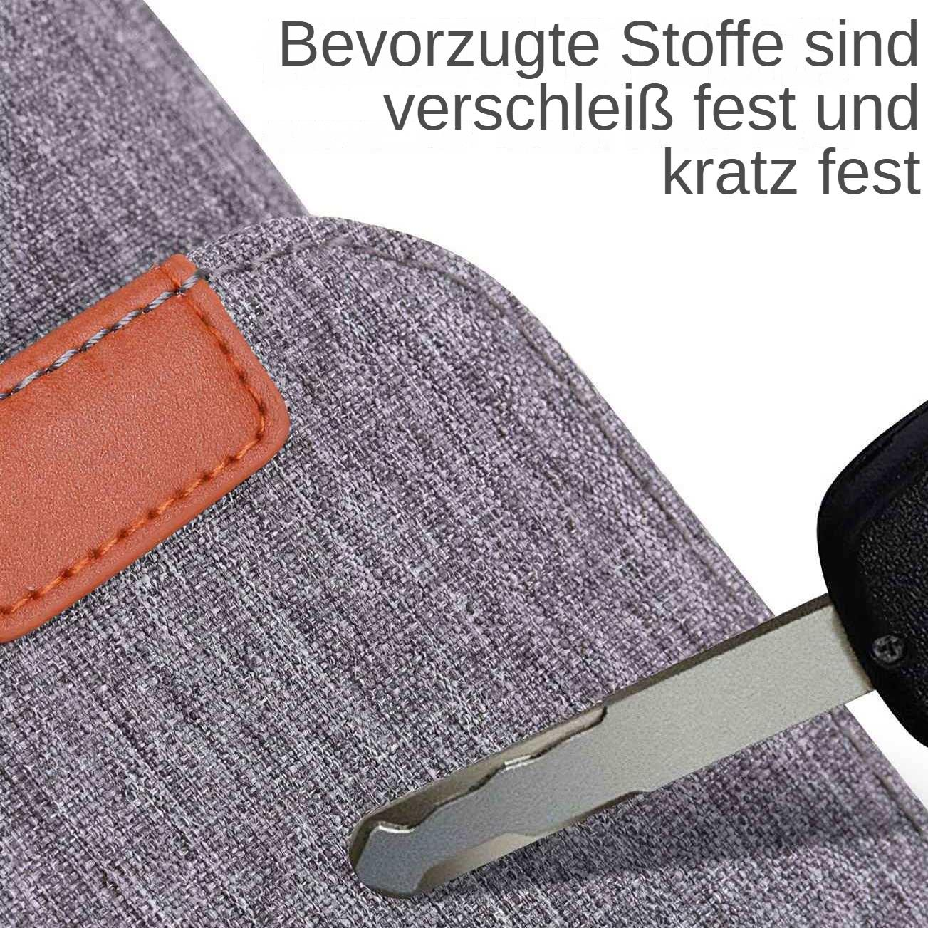 Nahaufnahme eines grauen Stoffes mit einem Lederaufnäher. Ein Autoschlüssel liegt auf dem Stoff. Text oben beschreibt Eigenschaften des Stoffes.