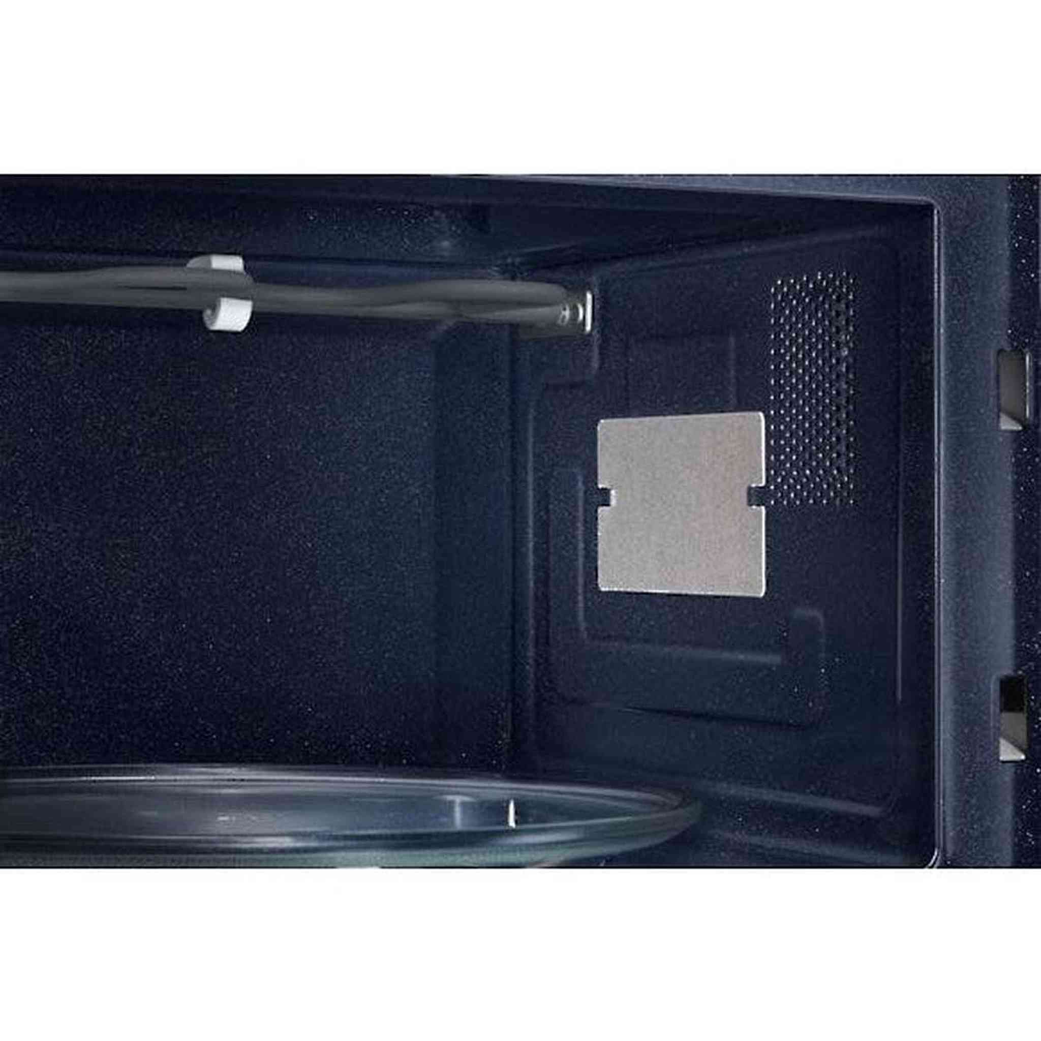All'interno di un forno a microonde. C'è un piatto di vetro, una piastra di metallo e un elemento riscaldante. L'interno è blu scuro.