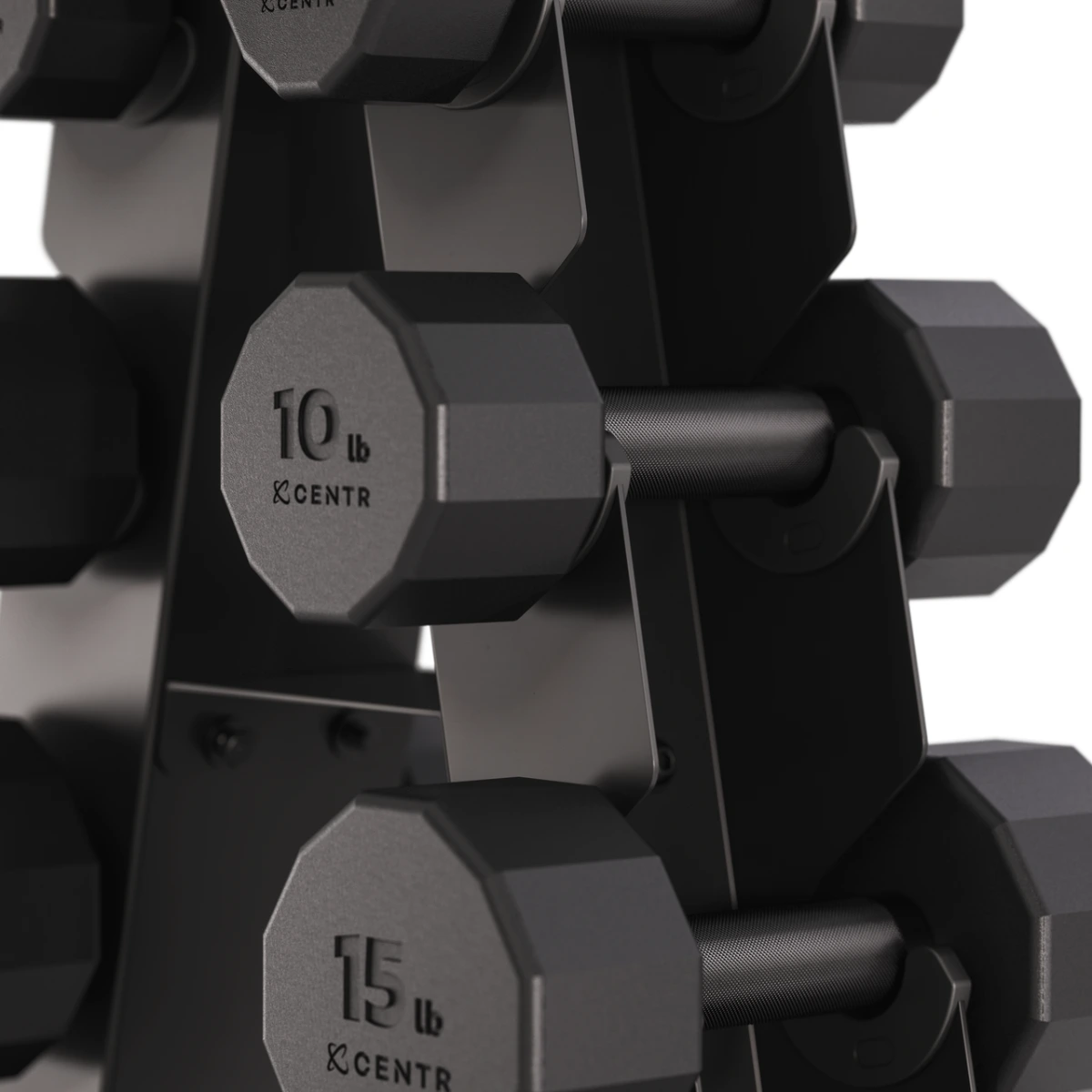 A close-up of a black dumbbell rack holding dumbbells. The dumbbells are labeled 10lb and 15lb. The rack is also black.