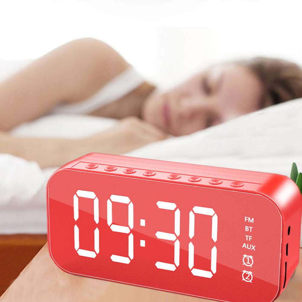 Eine rote Digitaluhr zeigt 09:30 Uhr an. Im Hintergrund schläft eine Person. Die Uhr hat FM-, BT-, TF-, AUX-Optionen.