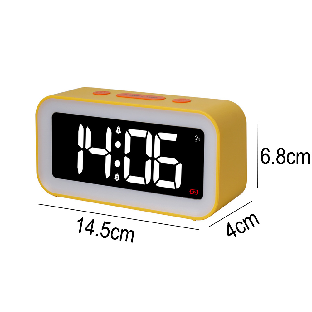 Ein gelber digitaler Wecker mit der Anzeige 14:06. Er hat einen weißen Rand, orangefarbene Tasten und die Maße 14,5 cm x 4 cm x 6,8 cm.