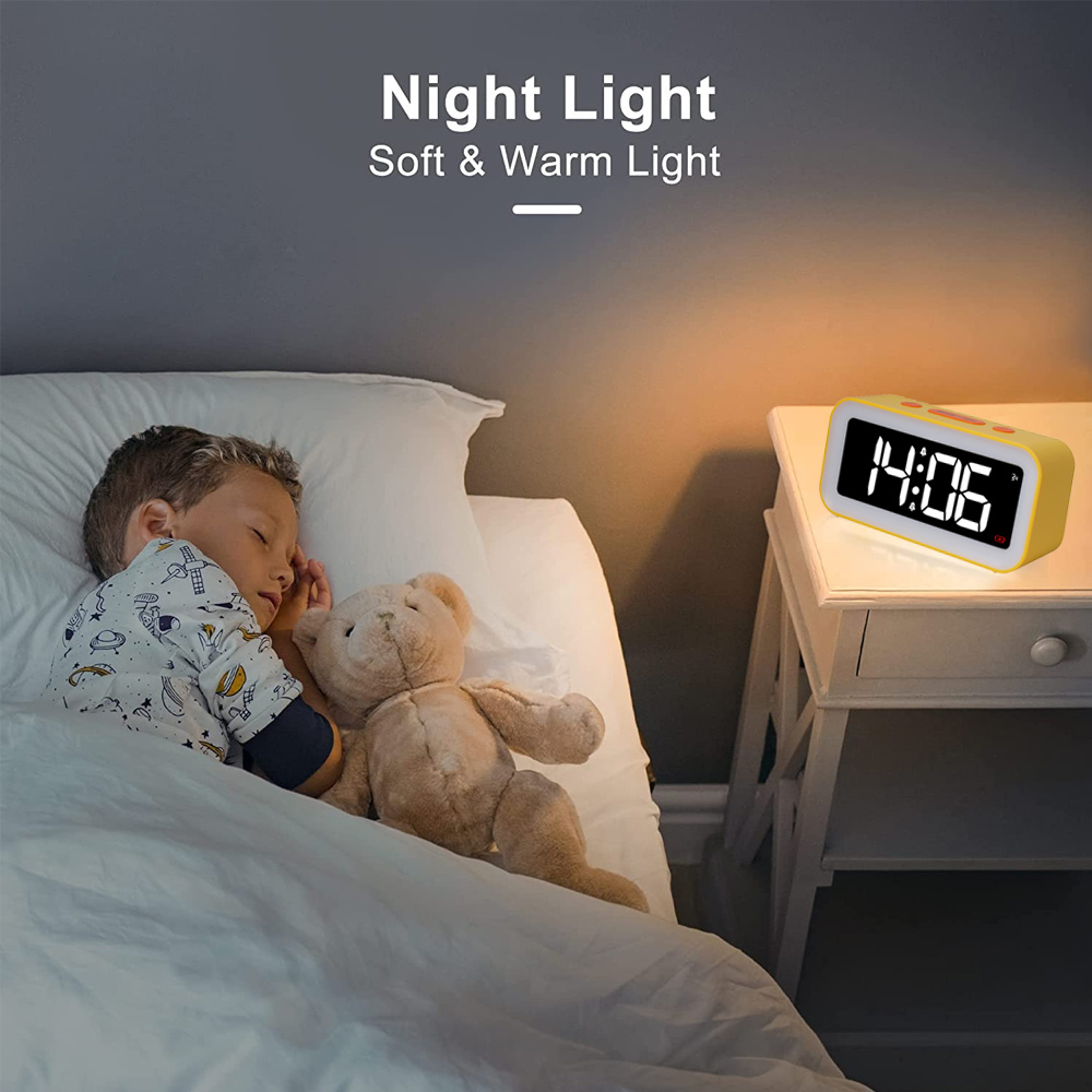 Ein Kind schläft im Bett mit einem Teddybären. Eine gelbe Uhr zeigt 14:06 auf einem Nachttisch. Der Raum ist schwach beleuchtet.