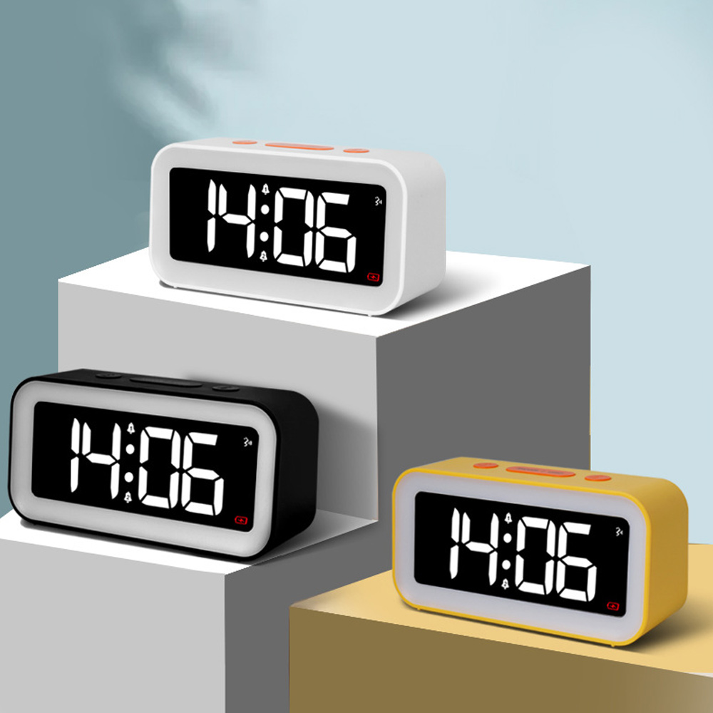 Drei digitale Wecker mit der Anzeige 14:06. Einer ist weiß, einer schwarz und einer gelb. Sie stehen auf verschiedenen Plattformen.