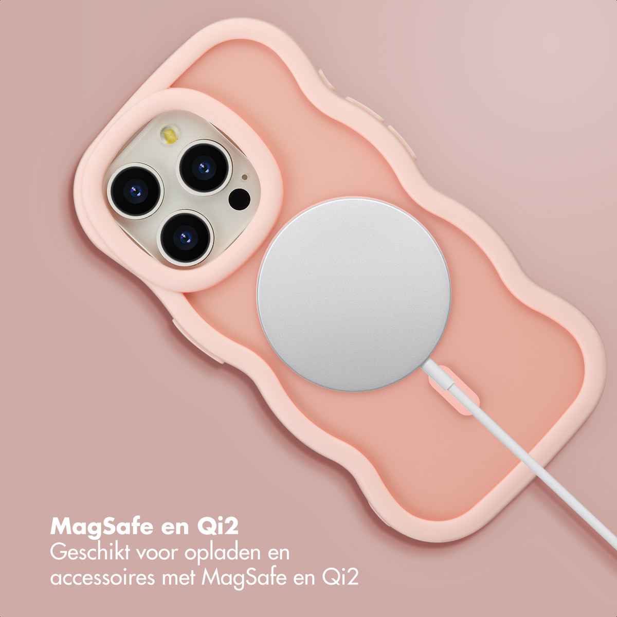 Een roze telefoonhoesje met een MagSafe-oplader bevestigd. De hoesje ligt op een roze ondergrond. Tekst onderaan beschrijft het product.