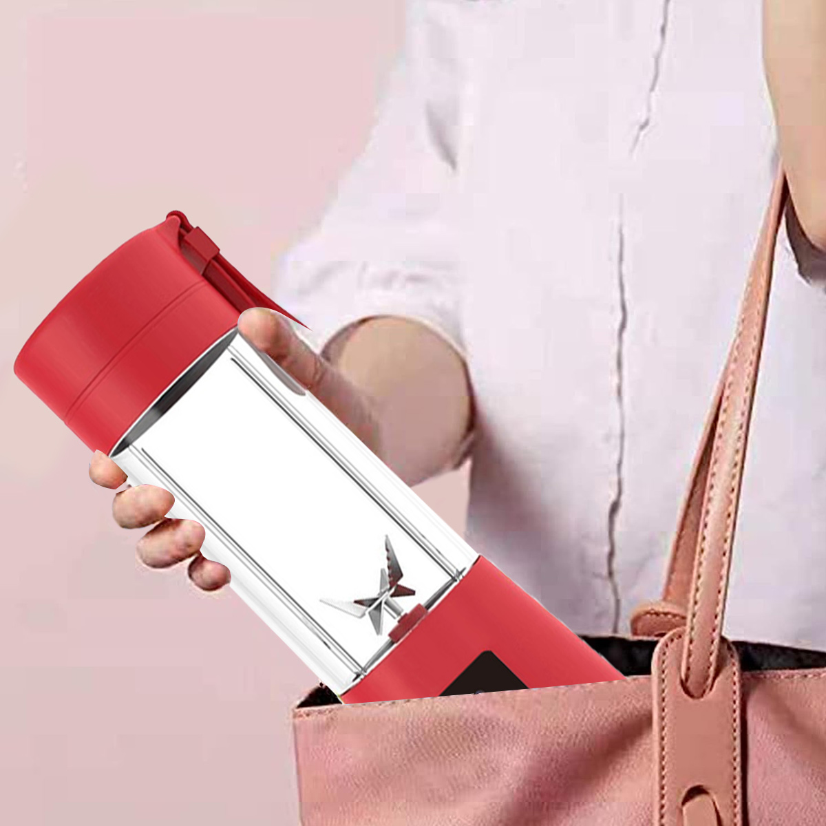 Eine Person hält einen roten und durchsichtigen Mixer. Er befindet sich teilweise in einer rosa Tasche. Die Person trägt ein weißes Hemd.