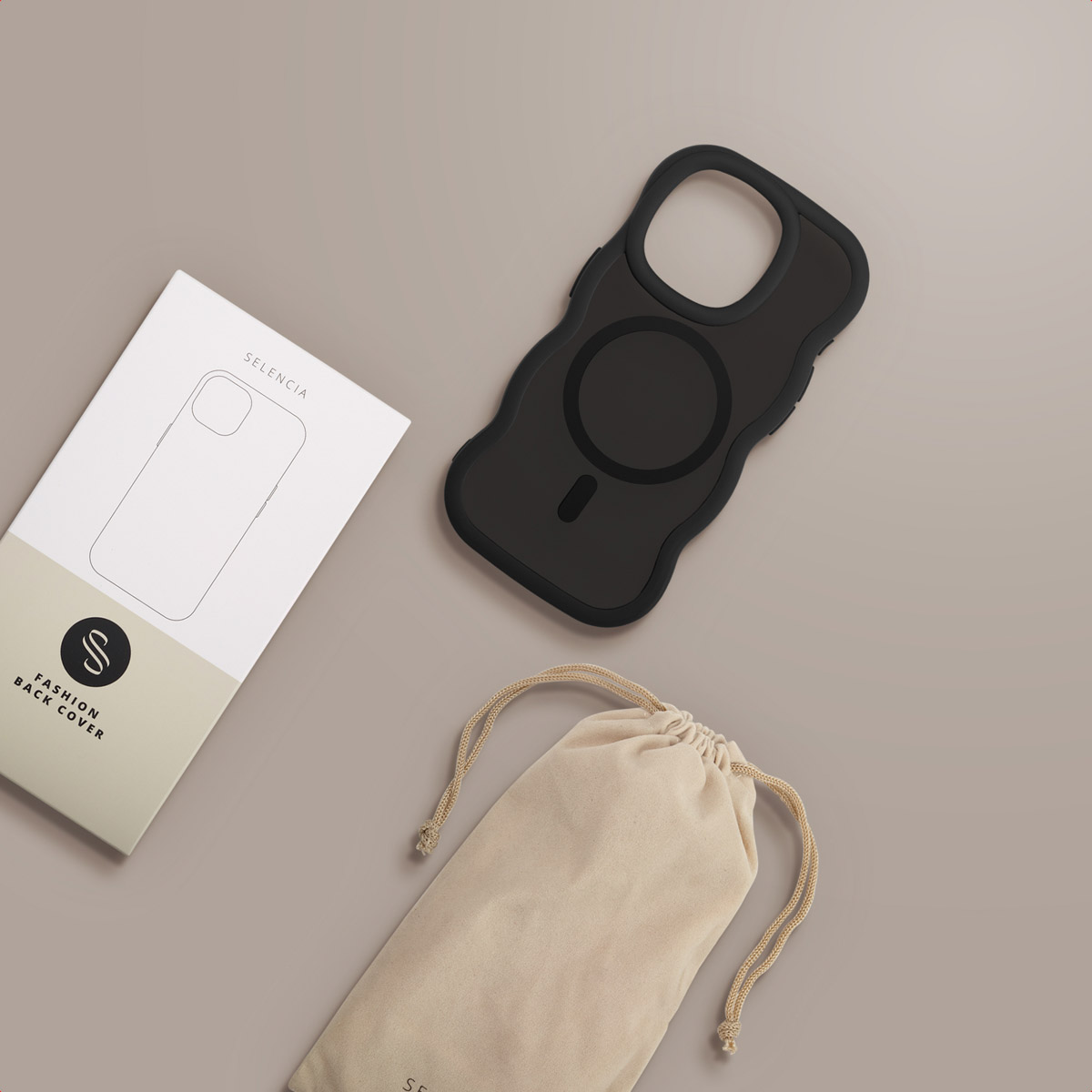Een zwarte telefoonhoes, een witte doos en een beige zakje met trekkoord liggen op een grijze ondergrond. De hoes heeft een magnetische cirkel.