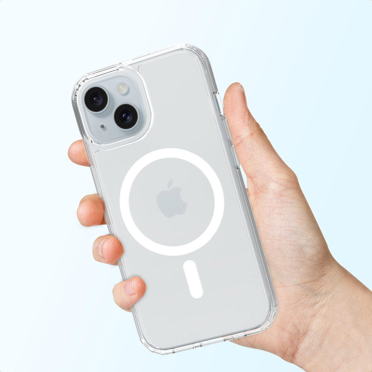 A hand holds a clear iPhone case with a white MagSafe circle and Apple logo. The background is a light blue gradient.