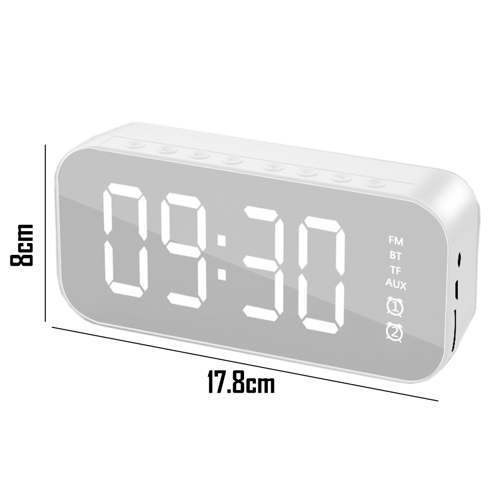 Ein weißer digitaler Wecker zeigt 09:30 Uhr an. Er hat Knöpfe, einen kleinen Lautsprecher und ein Display mit FM, BT, TF und AUX.