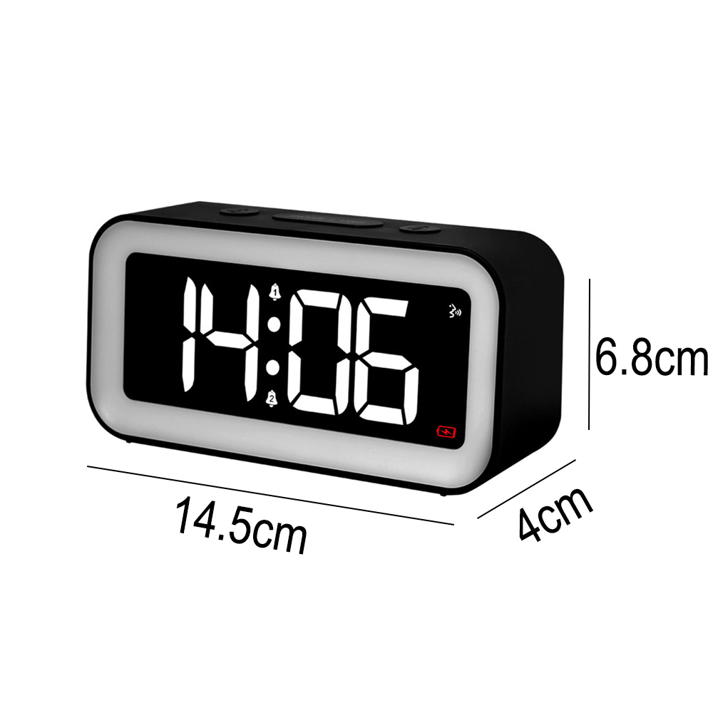 Schwarzer digitaler Wecker mit der Anzeige 14:06. Er hat weiß beleuchtete Zahlen, die Abmessungen sind 14,5 cm x 4 cm x 6,8 cm.