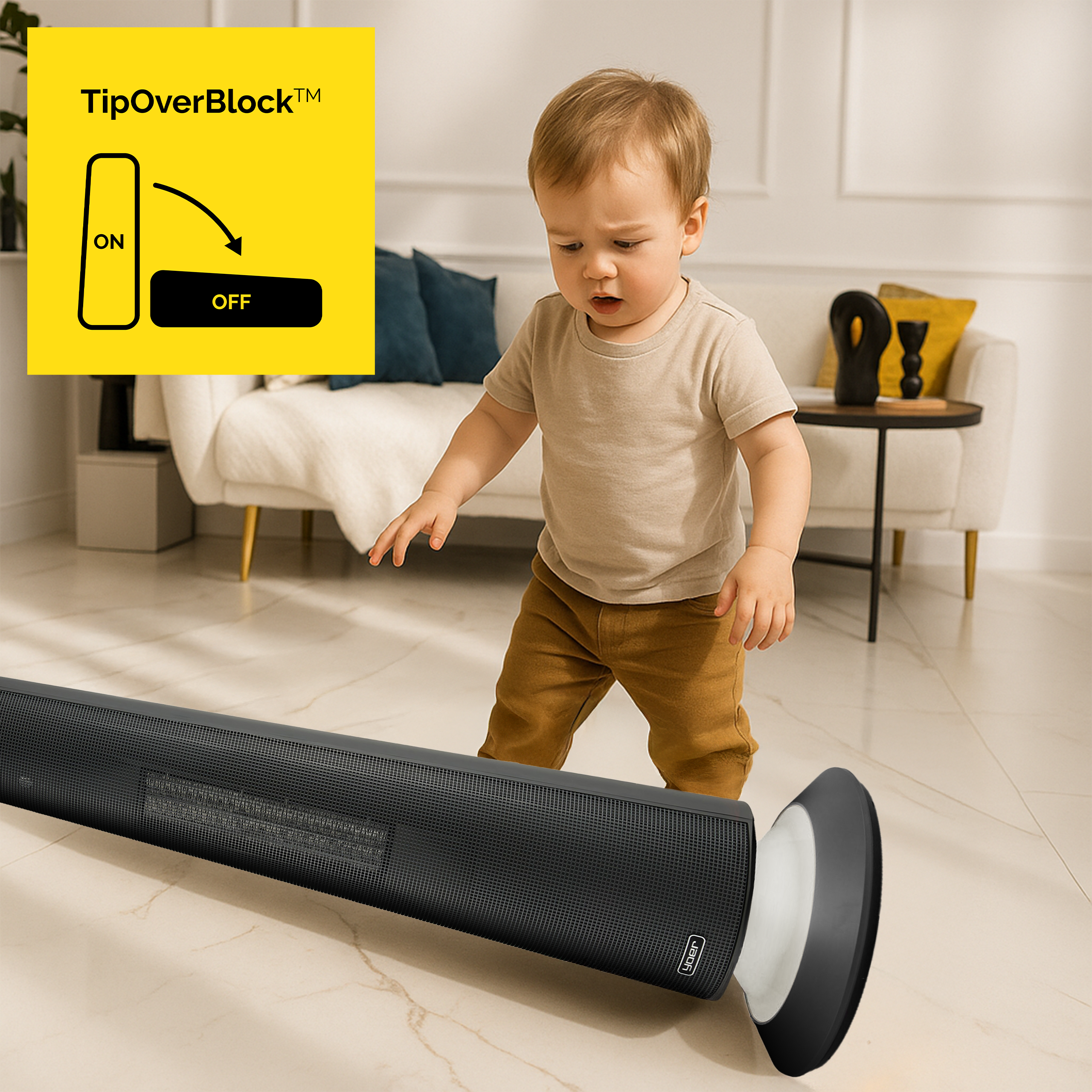 Niemowlę patrzy na przewrócony czarny grzejnik. Żółty znak mówi „TipOverBlock”. W tle sofa i stół.