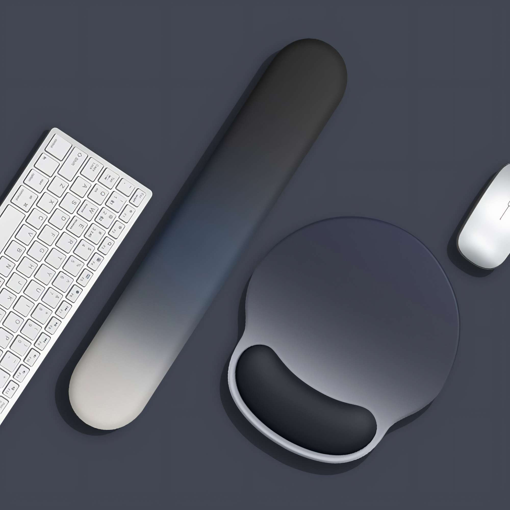 Tastatur, Handgelenkstütze, Mauspads und Maus auf dunkler Oberfläche. Artikel sind in Grau- und Weißtönen gehalten.