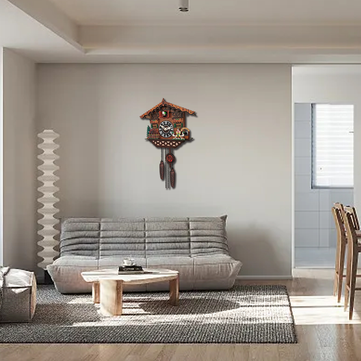 Eine Kuckucksuhr hängt an der Wand über einem grauen Sofa. Vor dem Sofa steht ein kleiner Holztisch. Ein Teppich bedeckt den Boden.