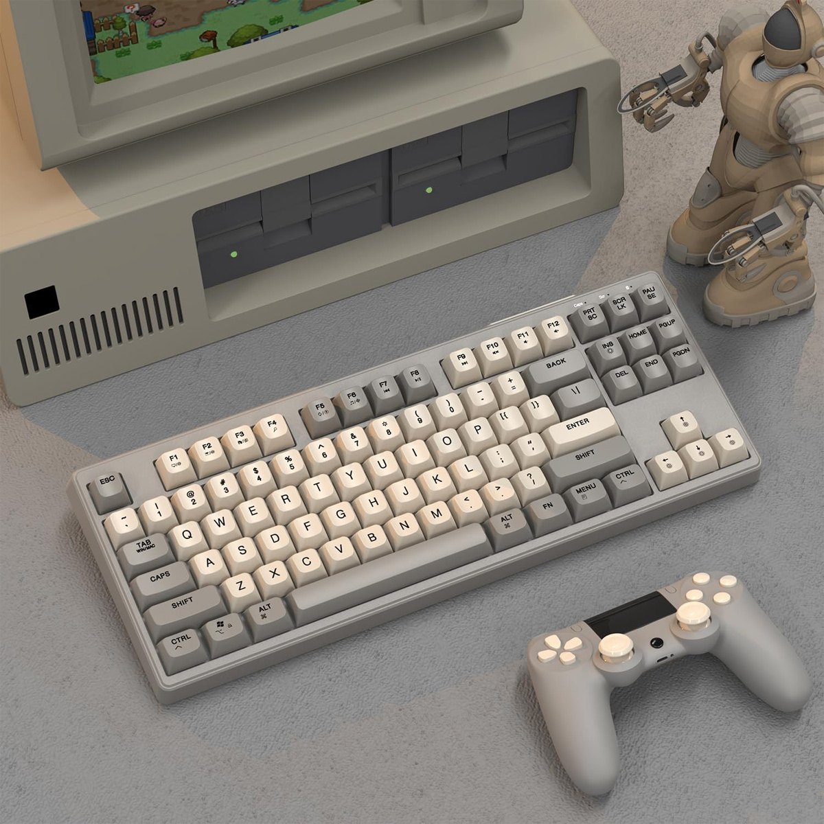 Eine Tastatur, ein Gamecontroller und ein Roboterspielzeug liegen auf einem Schreibtisch in der Nähe eines Computers.