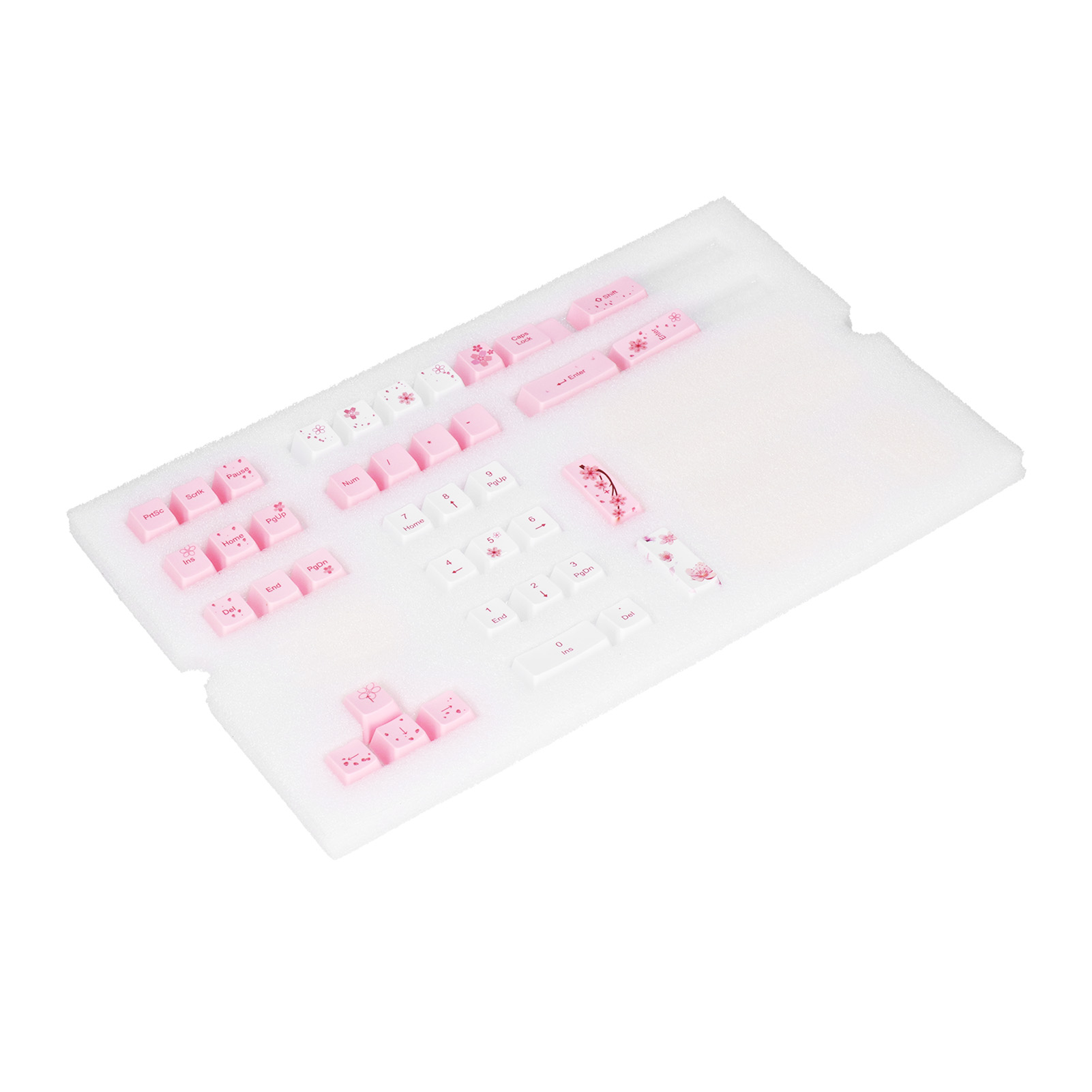 Eine Reihe von Tastaturkappen, weiß und rosa. Einige Tasten haben Blumendesigns. Sie liegen auf weißem Schaumstoff.
