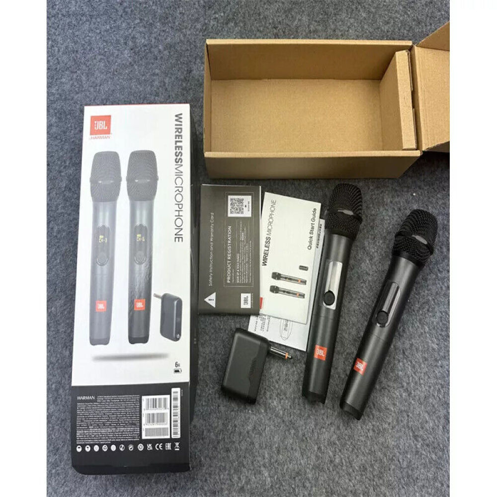 JBL-Funkmikrofone, Verpackung und Zubehör liegen auf grauem Untergrund. Artikel umfassen Mikrofone, Karton, Handb ücher und Ladegerät.