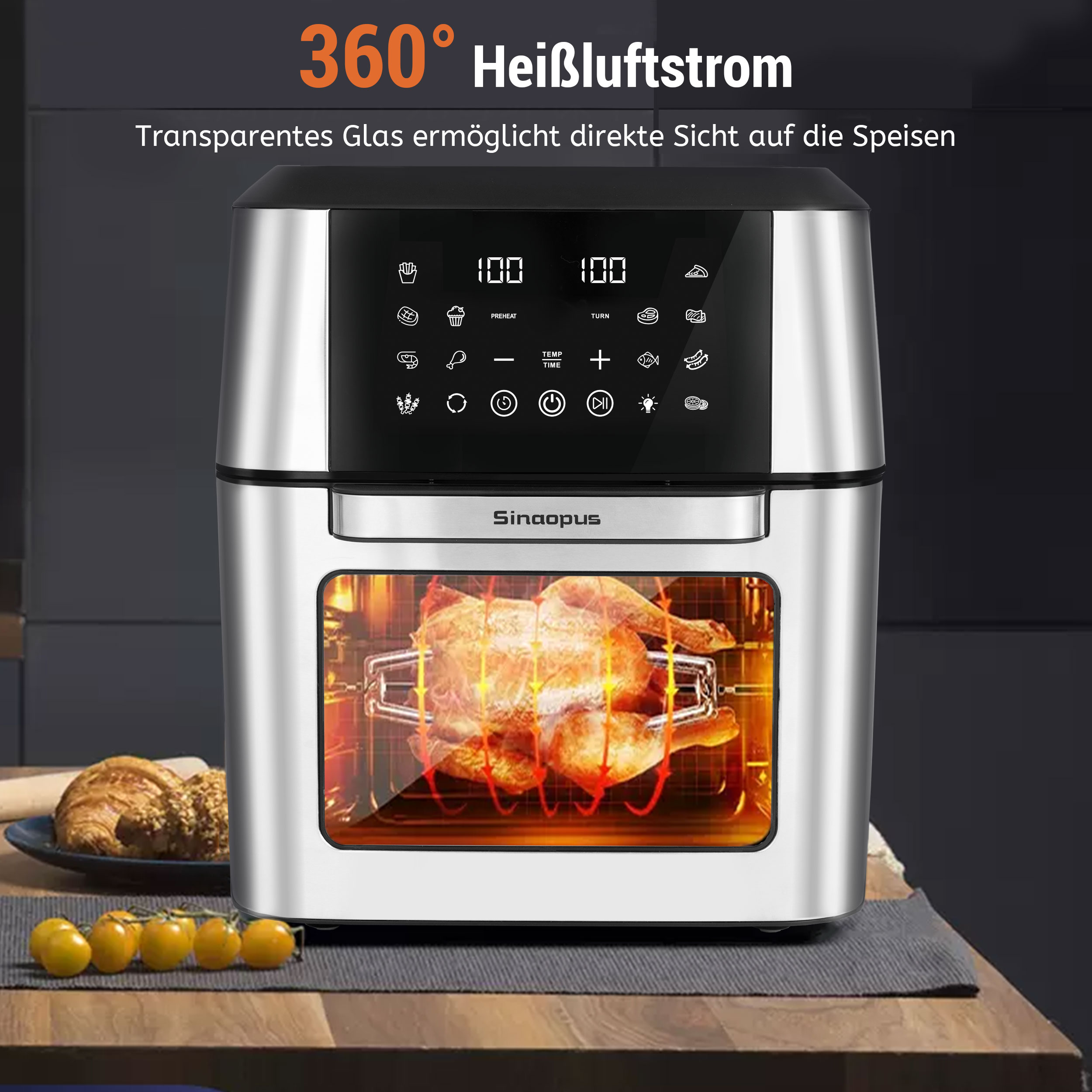 Ein Airfryer mit einem Huhn darin. Tomaten und Gebäck sind im Vordergrund.