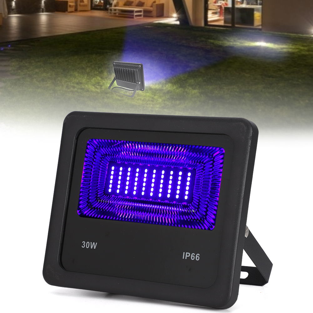 Schwarzer LED-Fluter mit lila Licht, das Gras beleuchtet. Im Hintergrund befindet sich ein kleineres Licht, das einen Terrassenbereich beleuchtet.