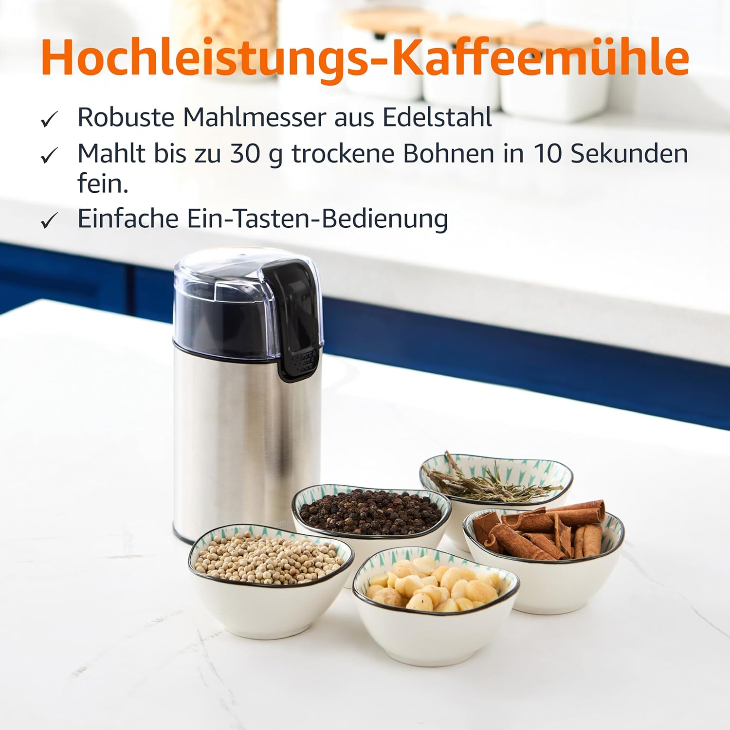 Eine Kaffeemühle mit Schalen voller Gewürze und Bohnen. Text in Deutsch hebt Eigenschaften wie Edelstahlklingen hervor.