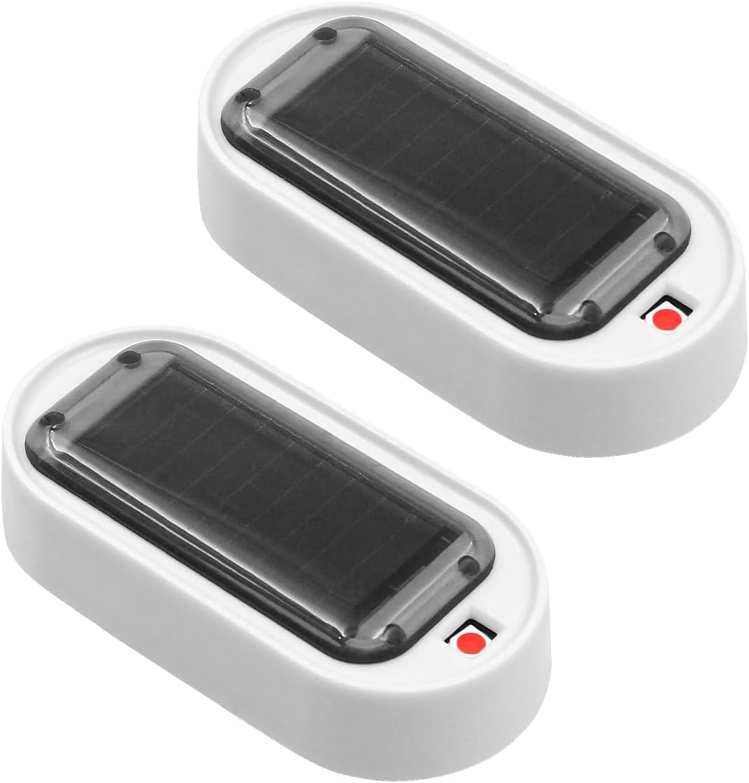 Zwei weiße, ovale Solarleuchten. Jede hat ein dunkles Solarpanel und ein rotes Licht. Klare Abdeckungen sind oben.
