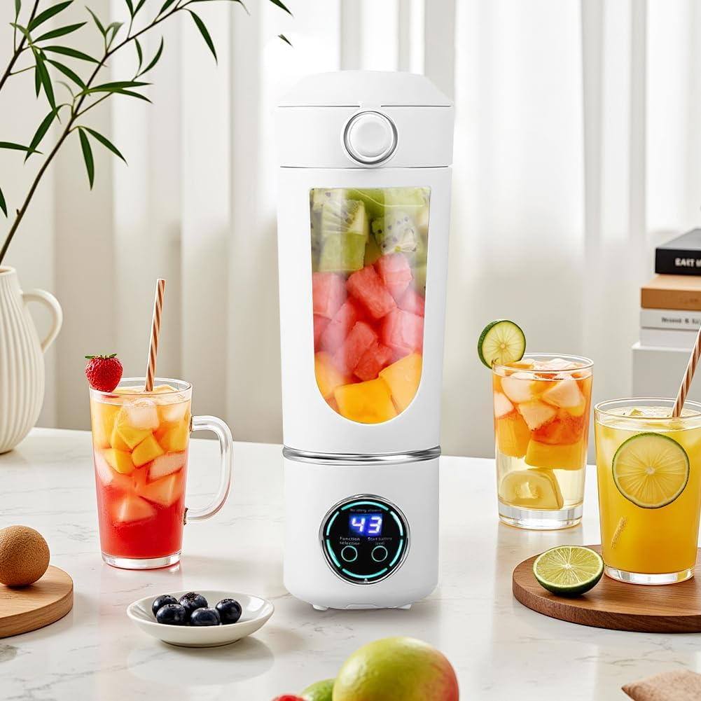 Ein weißer Mixer, gefüllt mit Früchten, neben Gläsern mit Saft, Früchten und einer Pflanze.
