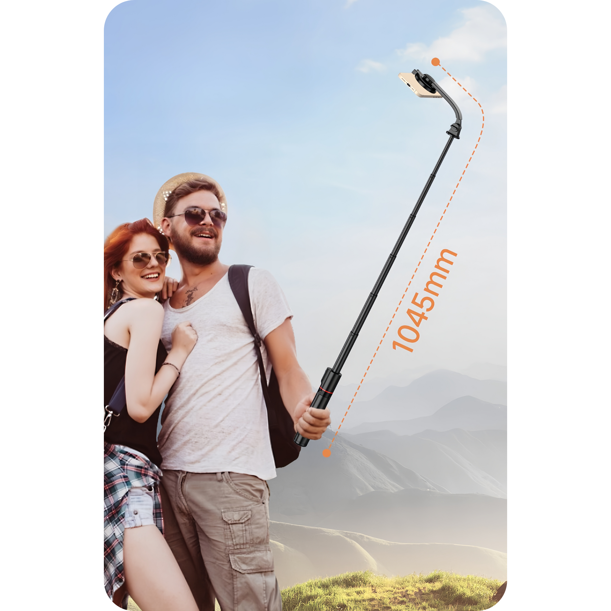 Ein Paar posiert draußen mit einem Selfie-Stick. Der Mann trägt einen Hut und eine Sonnenbrille, die Frau eine Sonnenbrille. Berge im Hintergrund.