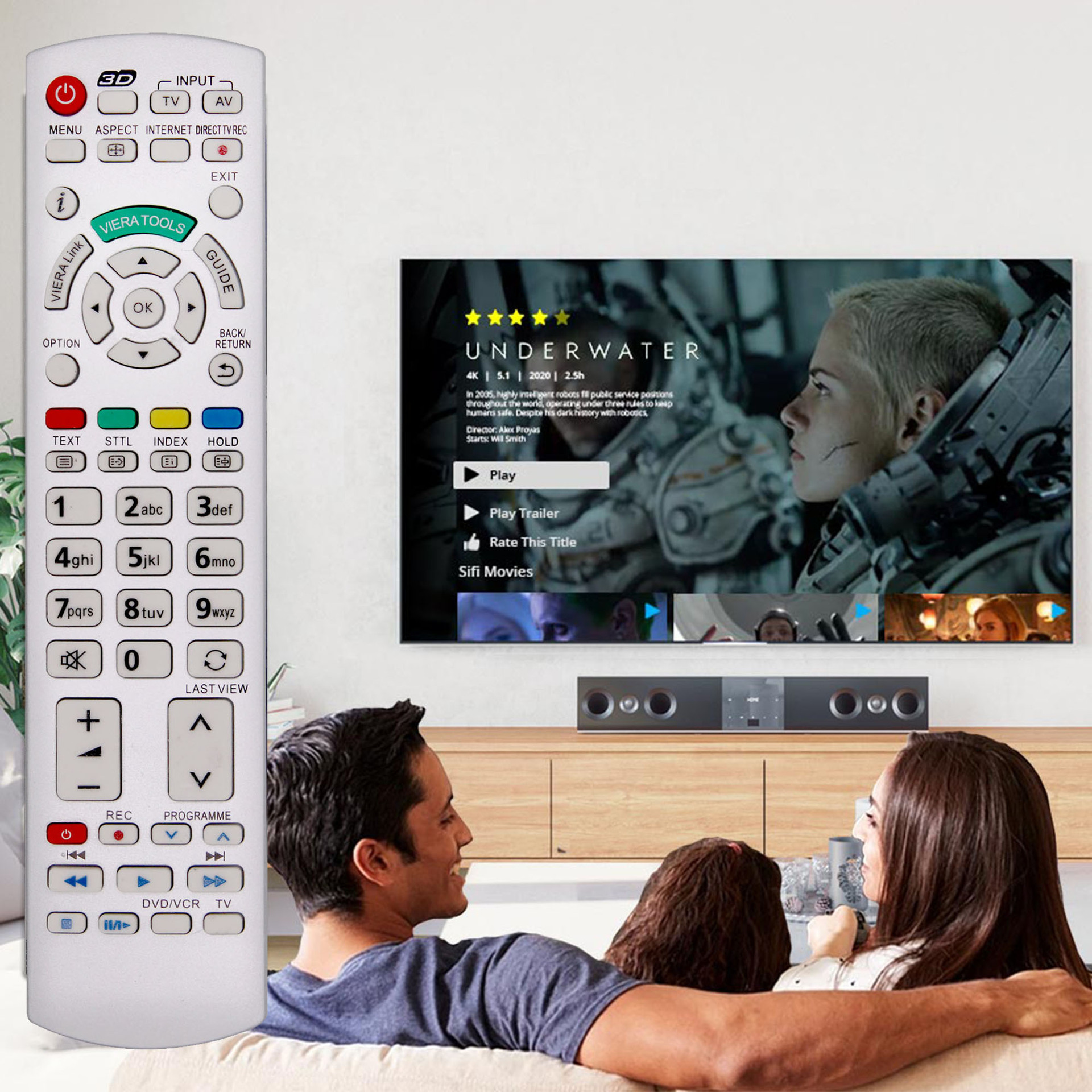 Eine Familie schaut einen Film im Fernsehen. Eine Fernbedienung ist im Vordergrund. Der angezeigte Film ist 'Underwater'.