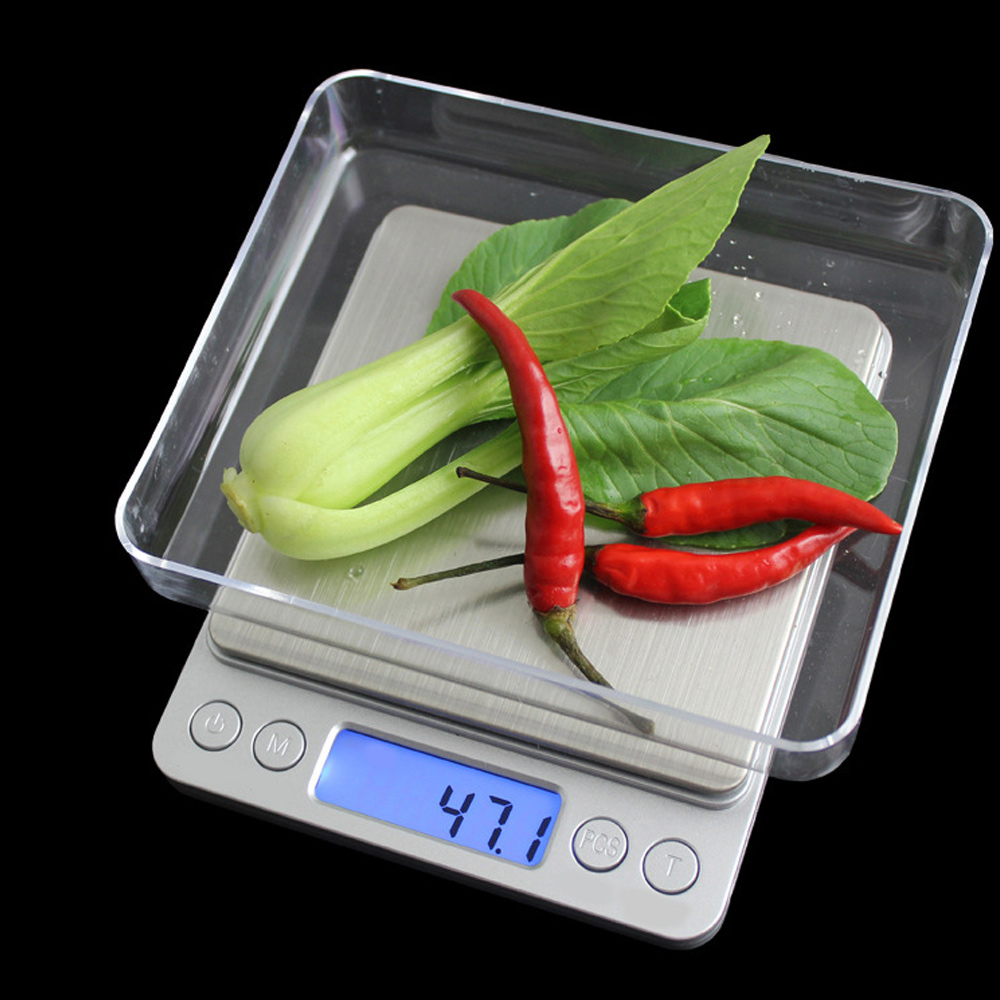 Digitale Waage mit Chinakohl, roten Chilischoten und Spinat in einer durchsichtigen Plastikschale. Die Anzeige zeigt 47,1.