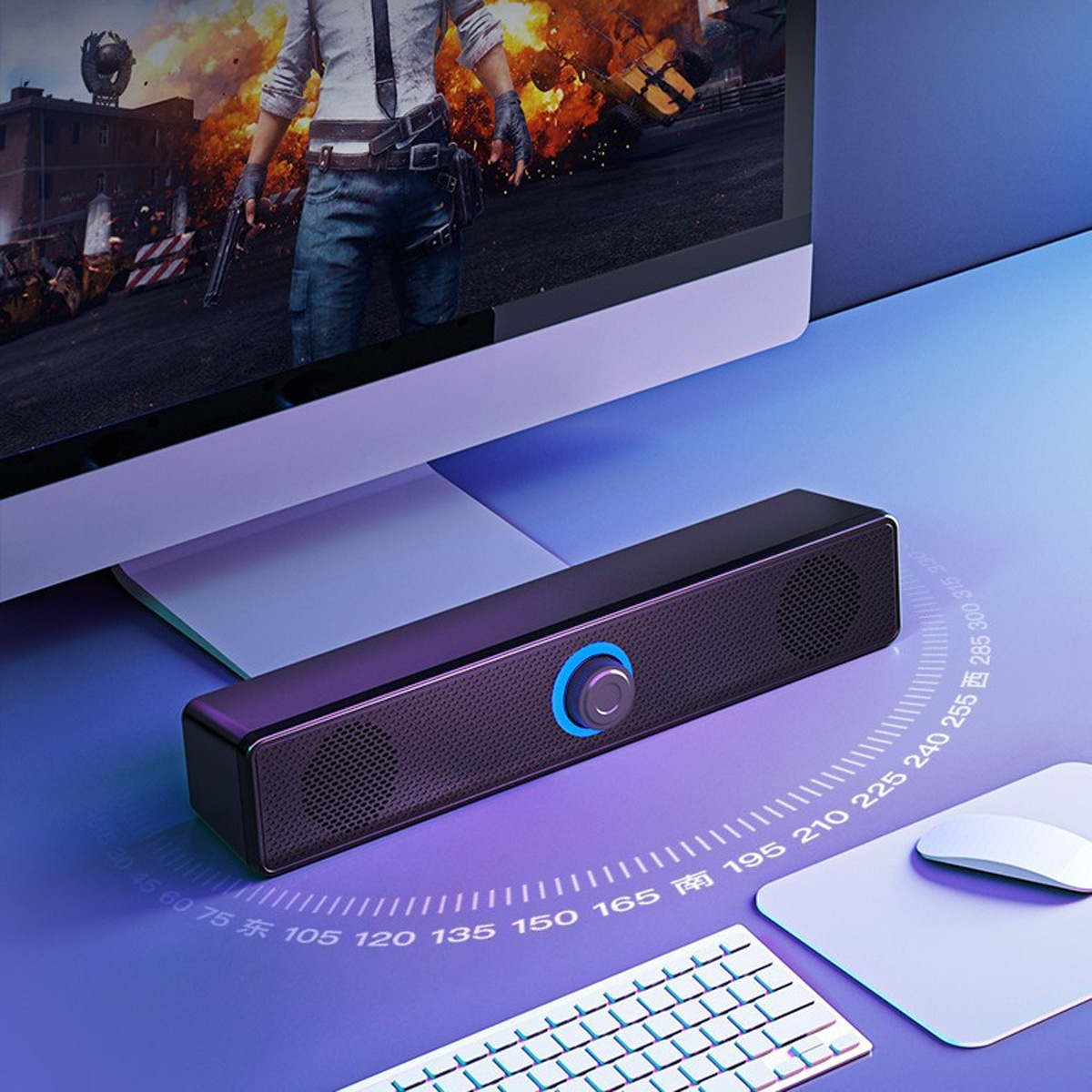 Eine schwarze Soundbar unter einem Monitor mit einer Spielszene. Tastatur, Maus und eine Farbverlaufsfläche sind ebenfalls sichtbar.