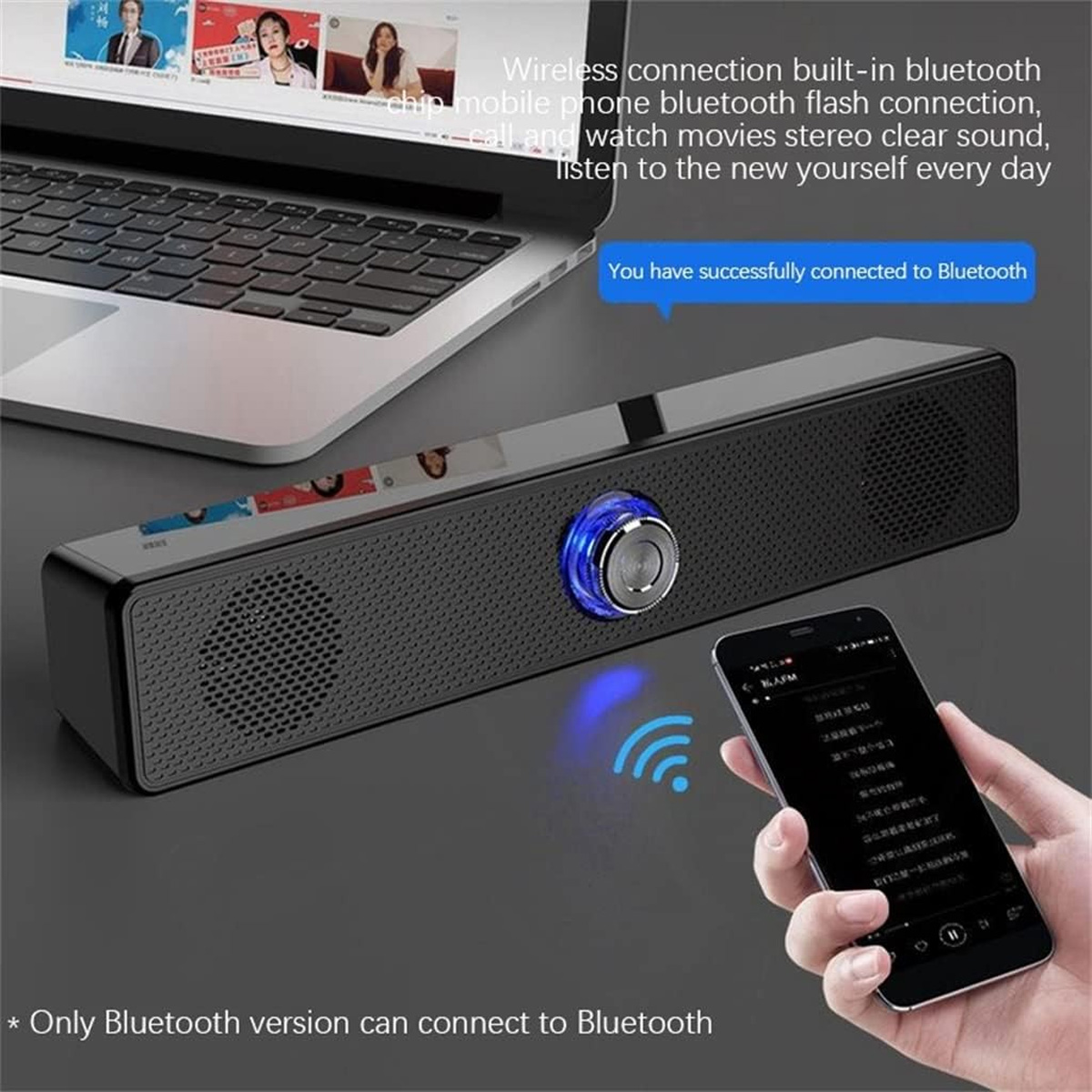 Ein schwarzer Lautsprecher ist über Bluetooth mit einem Telefon verbunden. Im Hintergrund befindet sich ein Laptop. Das Telefon zeigt eine Musik-App an.