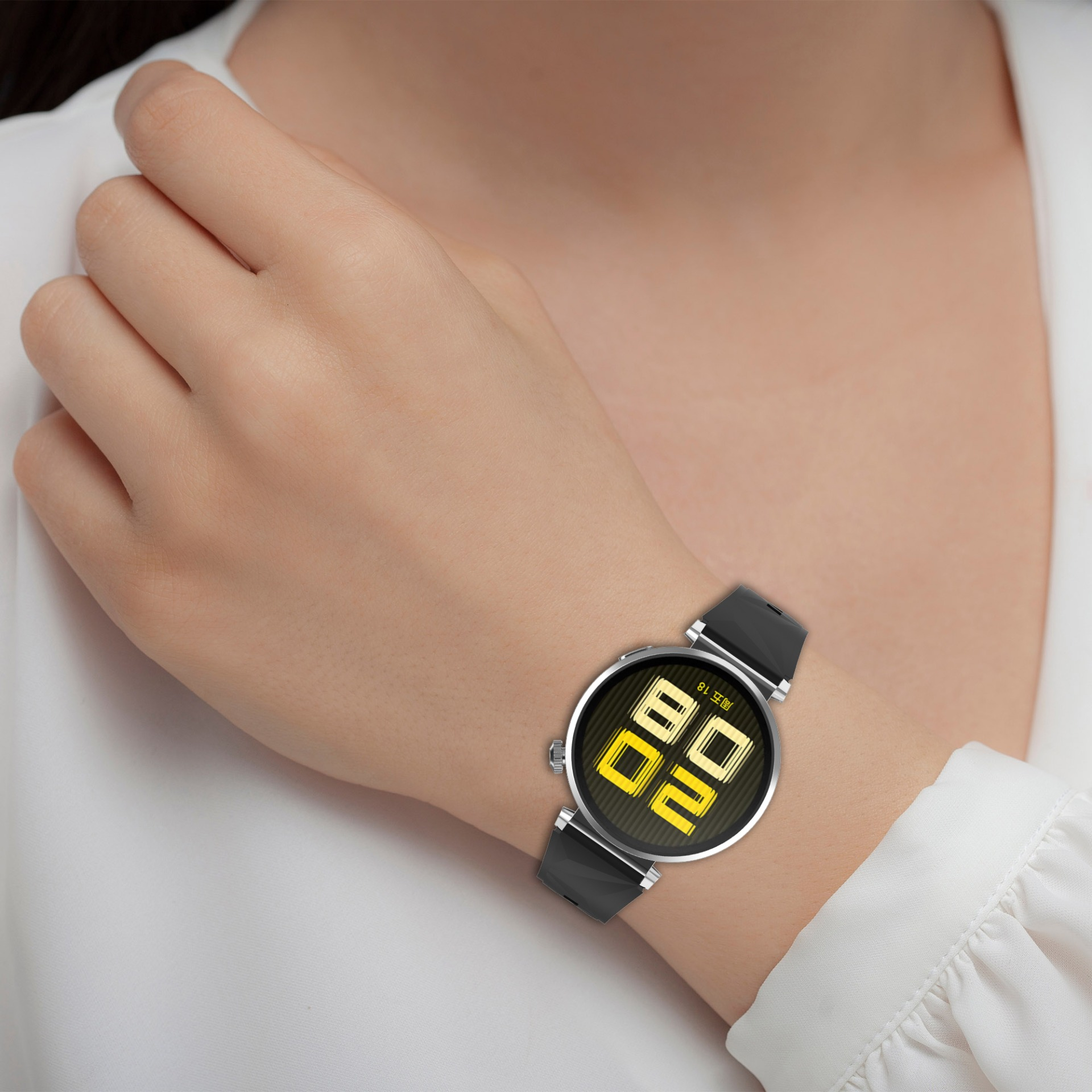 Il polso di una persona con uno smartwatch nero che mostra numeri digitali gialli. La persona indossa una camicia bianca a maniche lunghe.