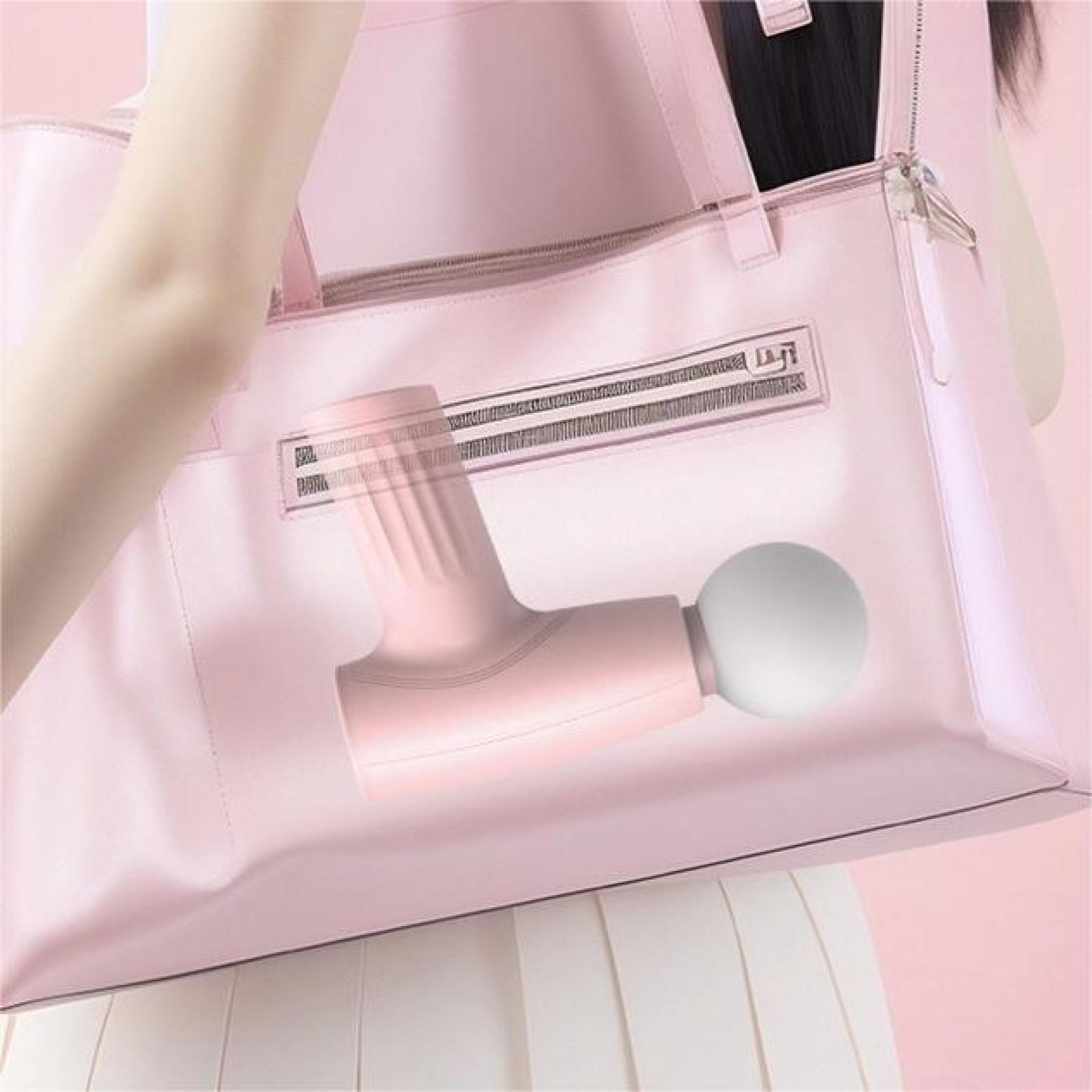 Pinke Massagepistole in einer rosa Tasche. Eine Person hält die Tasche. Weißer Rock ist sichtbar.