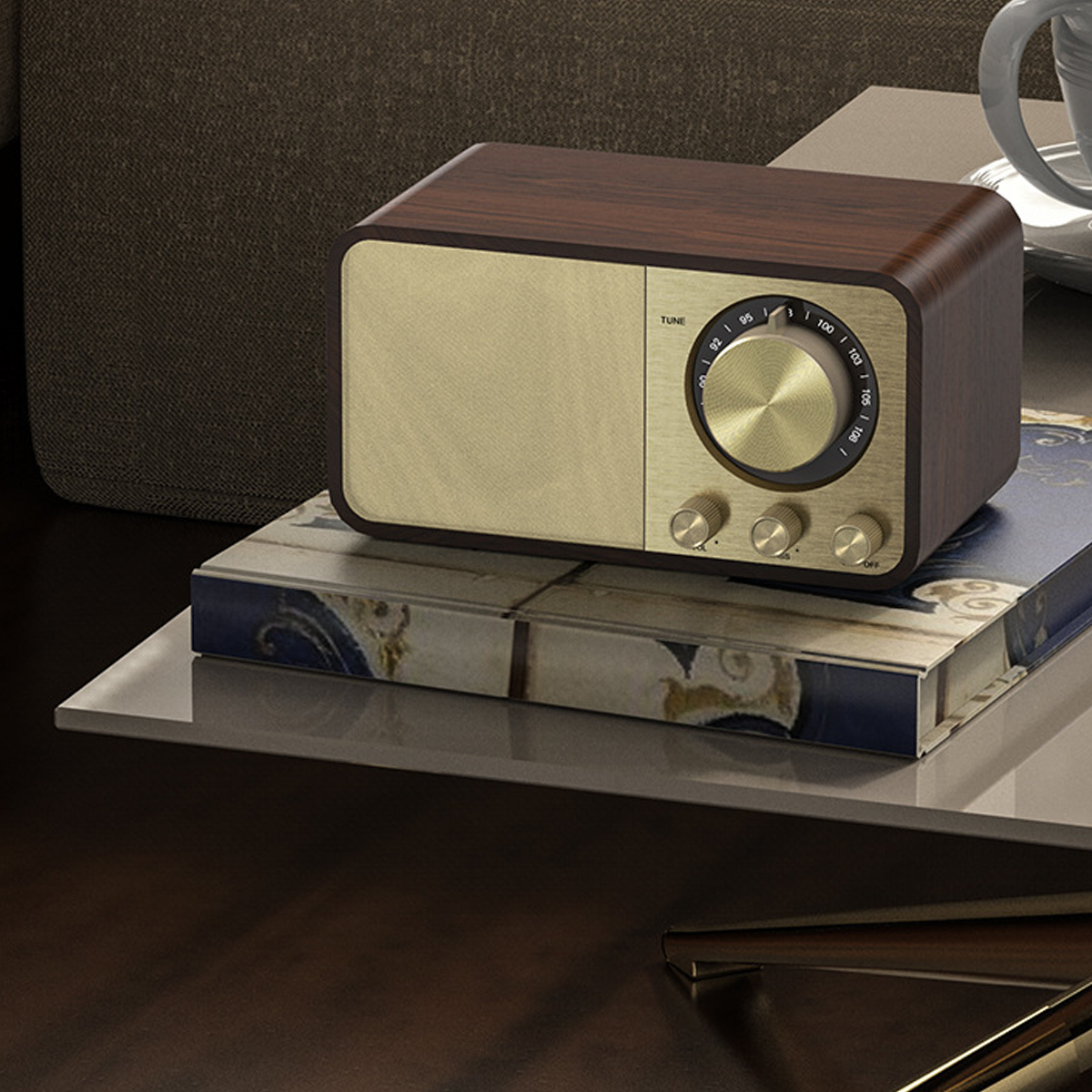 Ein Vintage-Radio mit Holzoberteil und goldener Front steht auf einem Buch. Die Szene umfasst einen Couchtisch und einen verschwommenen Hintergrund.