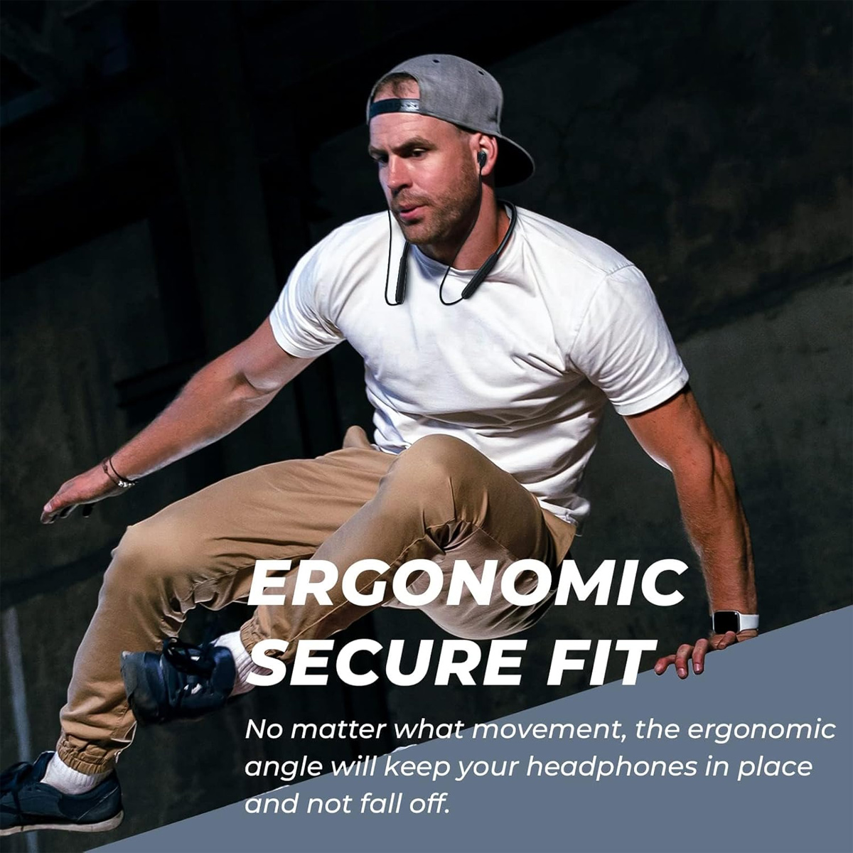 Mann mit Kopfhörern beim Springen. Er trägt ein weißes T-Shirt, beige Hose und eine graue Kappe. Text: ergonomische sichere Passform.