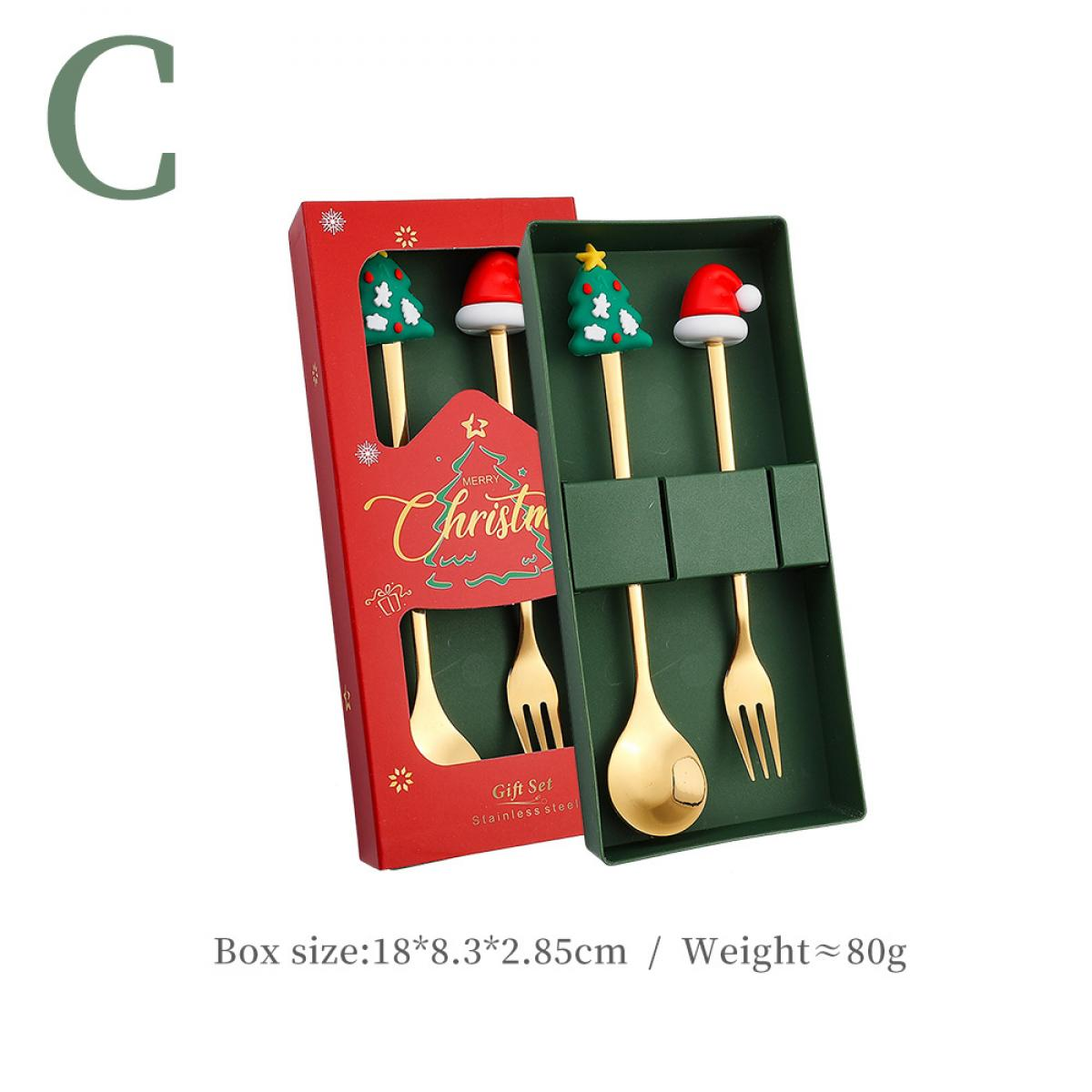 Ein Weihnachtsgeschenkset mit goldenen Löffeln und Gabeln sowie Baum-/Weihnachtsmützen-Toppern in roten und grünen Boxen.