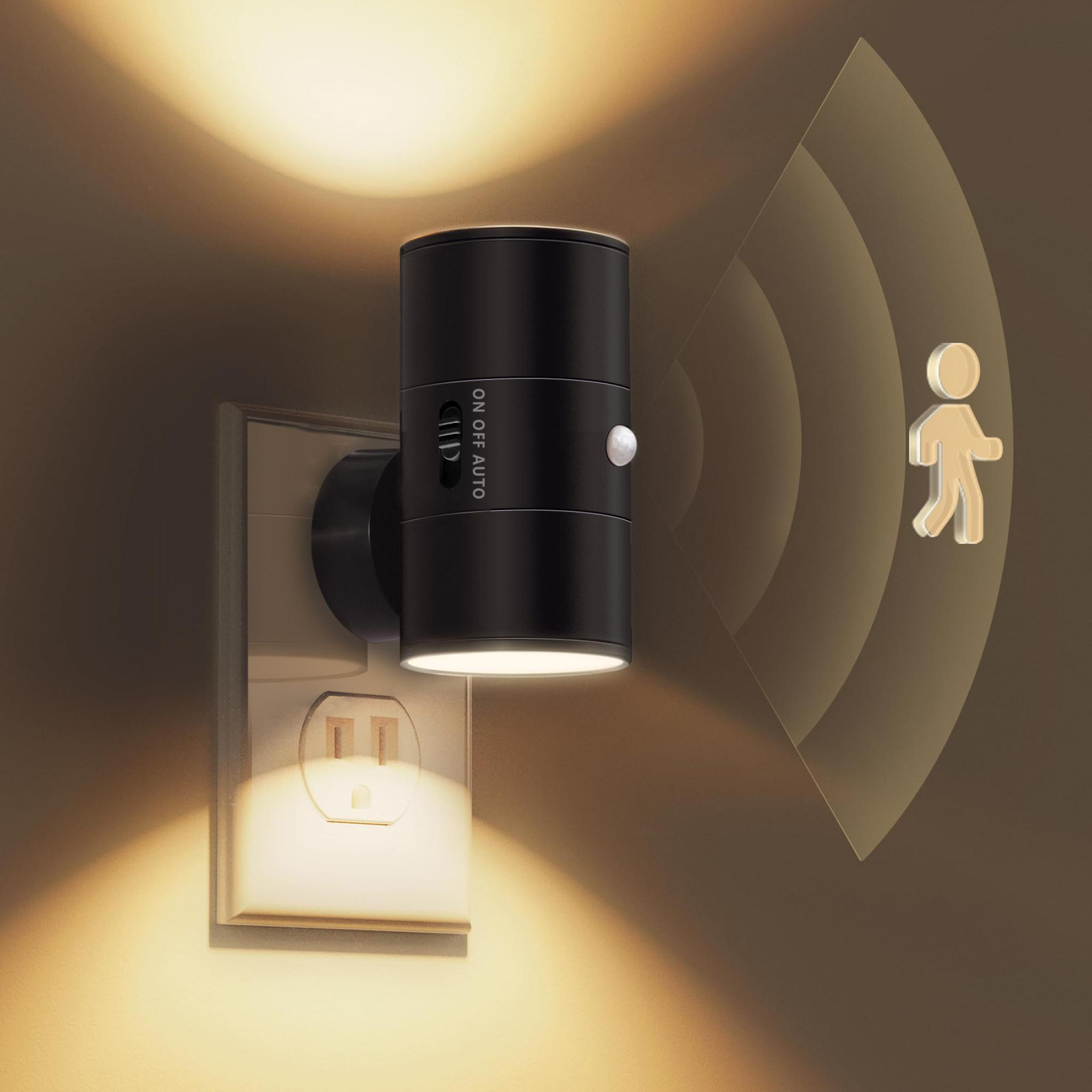 Ein schwarzes Nachtlicht mit einem ON/OFF/AUTO-Schalter, das in eine Steckdose gesteckt ist, mit einem Bewegungserkennungssymbol.