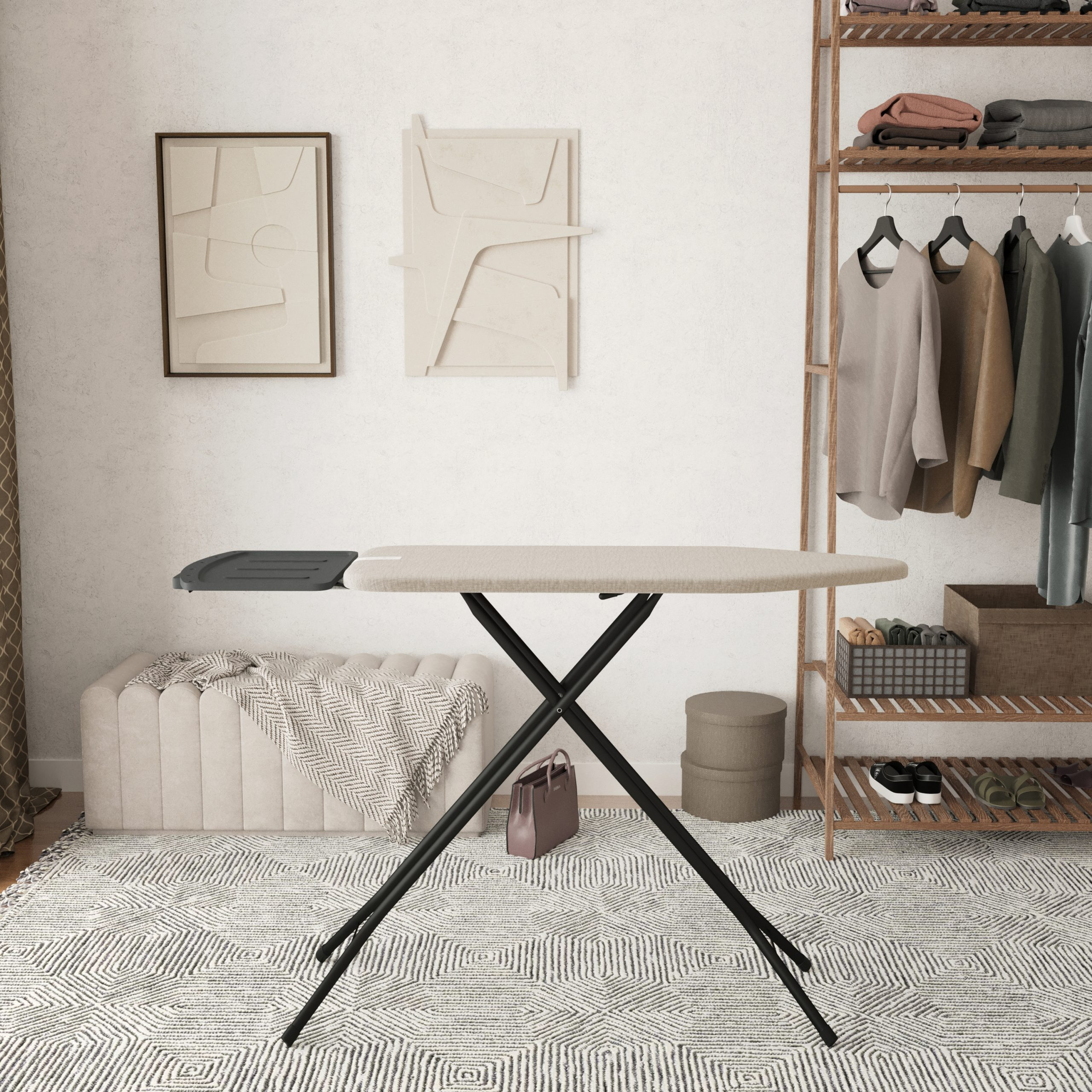 An ironing board is in the center. Clothes and a bench are in the background. Abstract art on the wall.