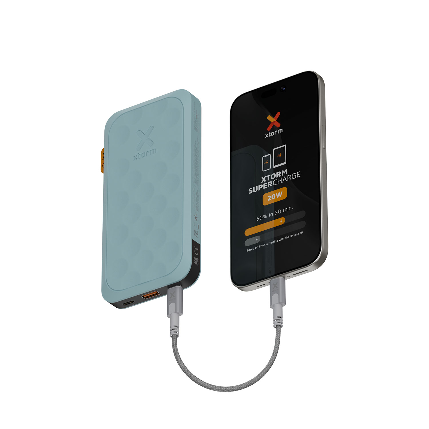 Un banco de energía azul conectado a un teléfono que muestra información de carga. El teléfono muestra 'XTORM SUPERCHARGE 20W' y un estado de carga.