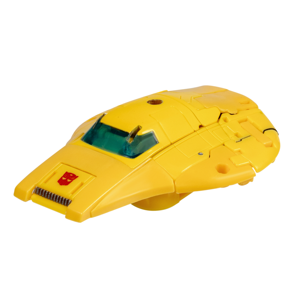 Un veicolo giocattolo giallo con finestra verde, emblema rosso e design complesso. Lo sfondo è bianco.